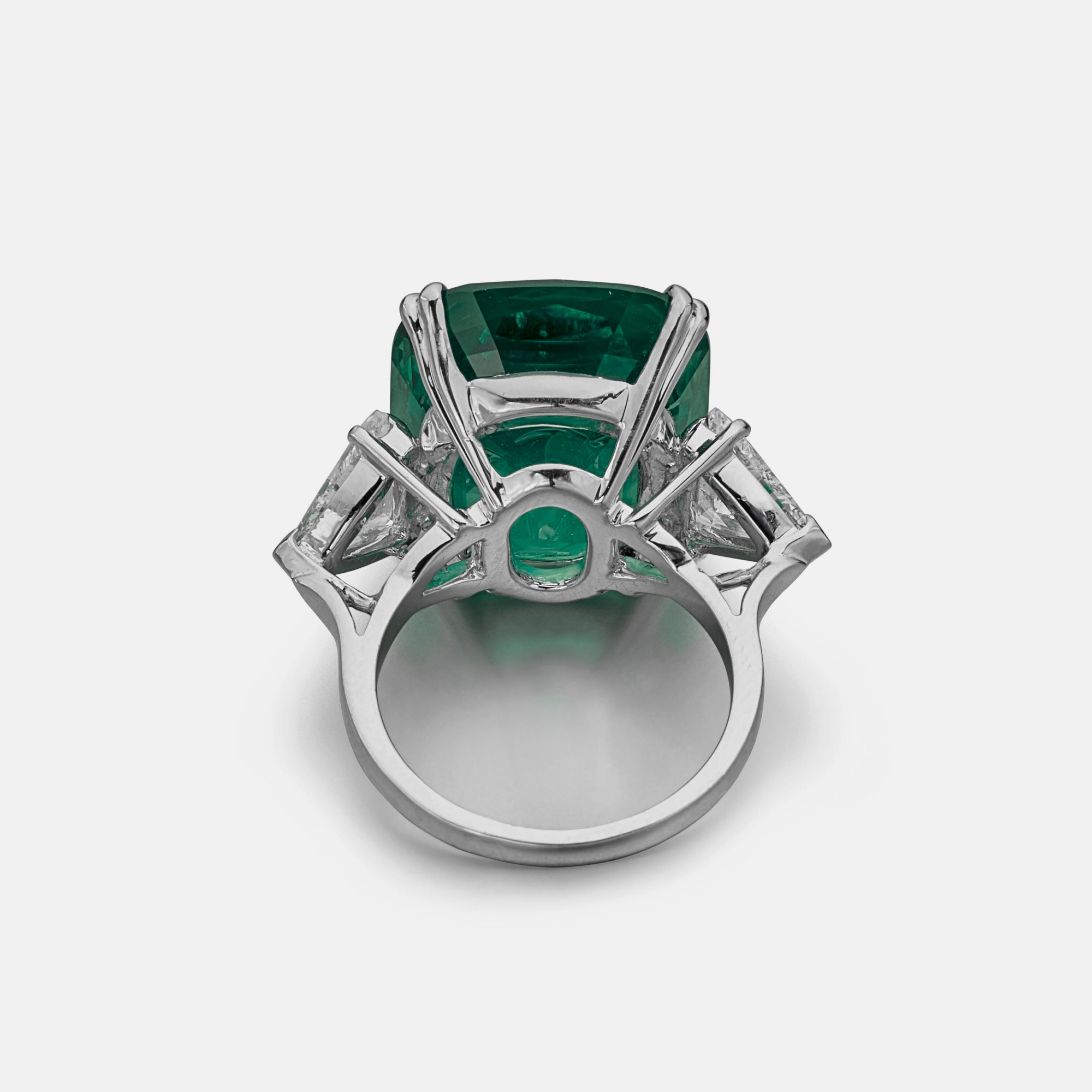 Centering an 7.51 ct.  green emerald, flanked by trillion cut shaped diamonds
Size 6
Platinum
Accompanied by GIA report
