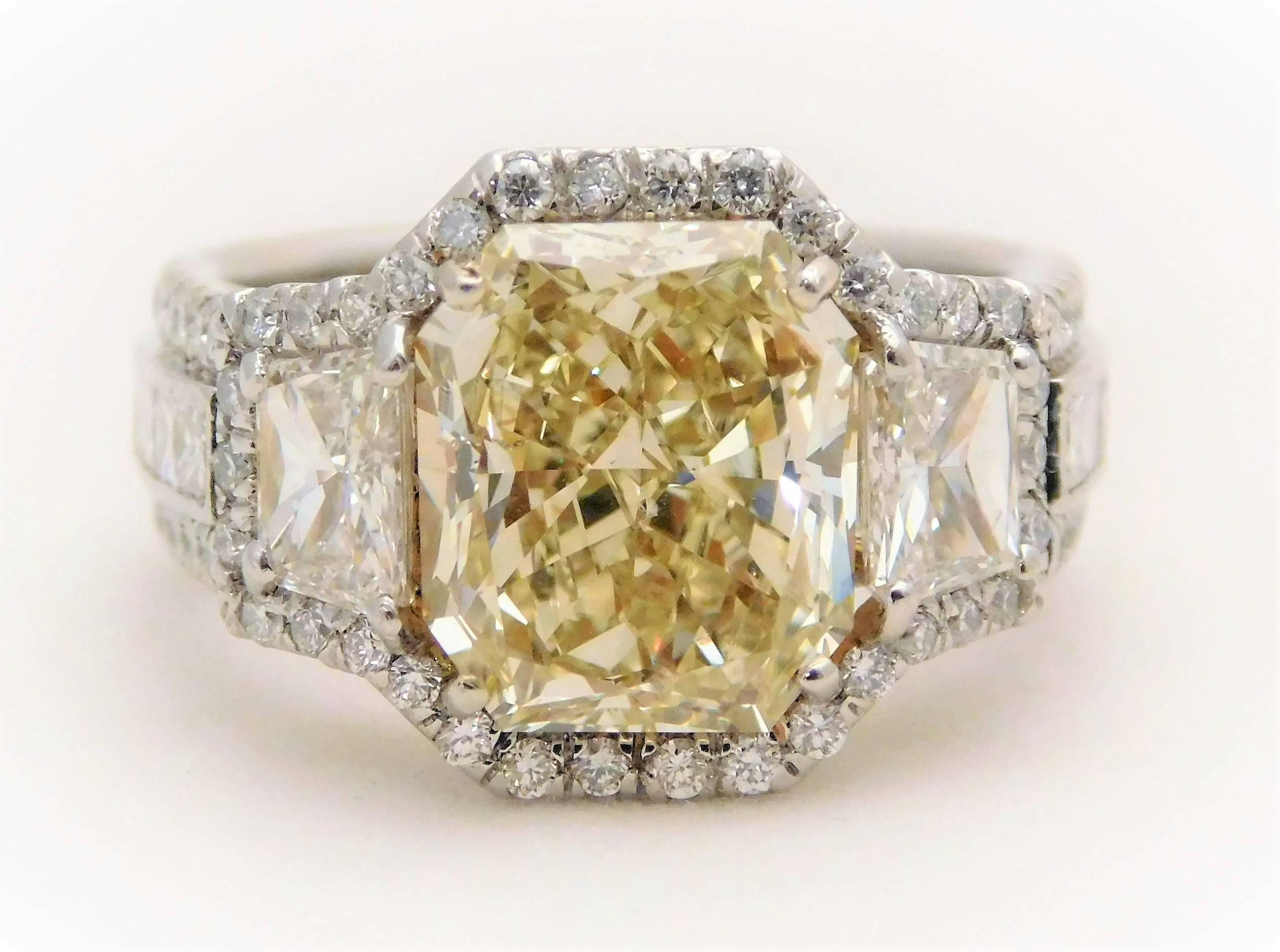 Circa 2018.  Handcrafted in solid platinum, this spectacular ring is a true work of art.  It has been masterfully jeweled with a GIA certified(#2145168278) 4.07ct Natural fancy yellow diamond as its dazzling center stone.  Flanking this rare diamond