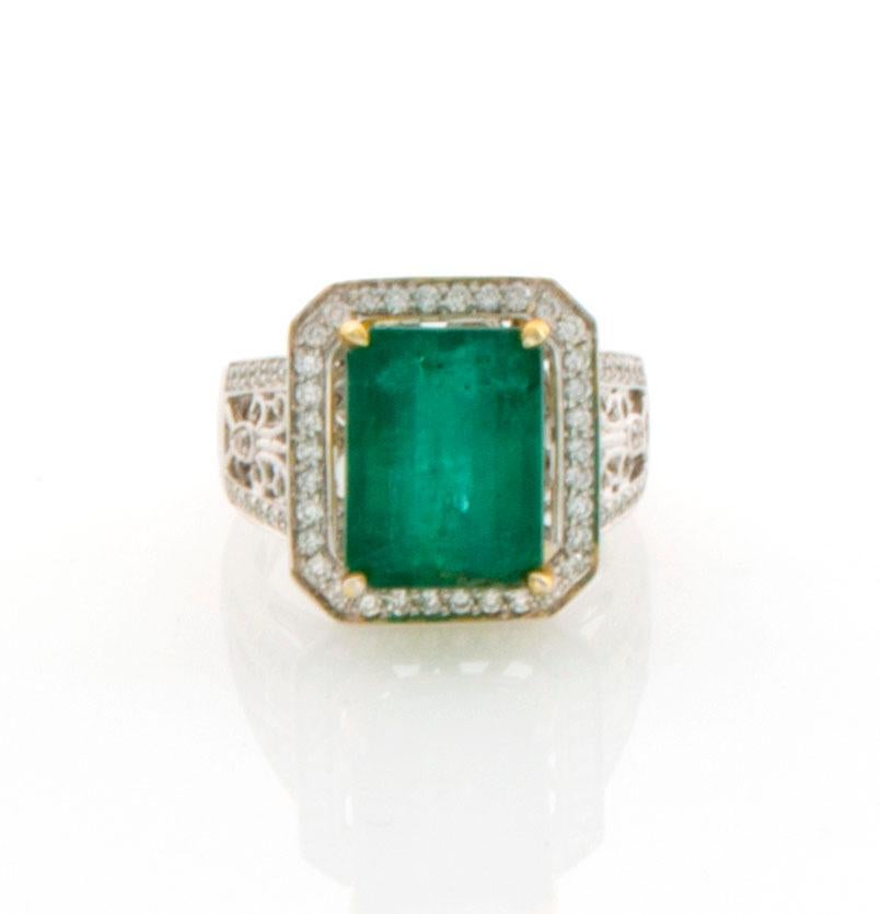 GIA Certified 7.65 Carat Emerald Diamond Ring Set in 14 Karat White and Yellow Gold. Prong set in a cathedral style setting with 58 shared prong set diamonds, VS2-SI2 clarity, color F-G equaling 0.71 carats and 2 claw set diamonds 0.03 carats.