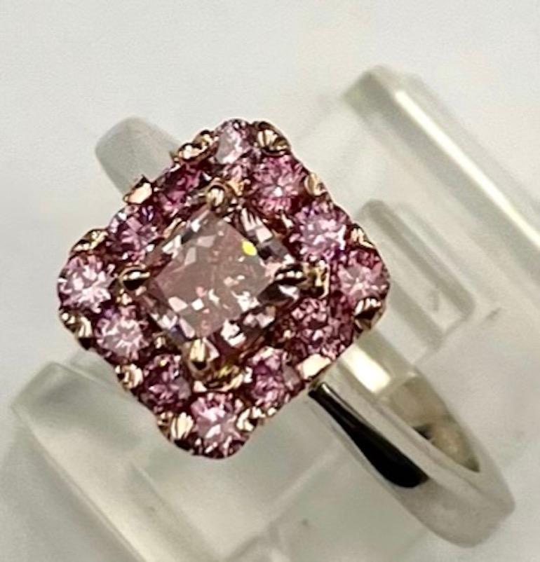 This is an absolutely beautiful and elegant ring. The center diamond is a very rare .76Ct Radiant Cut Diamond that is a Natural Fancy Intense Purplish Pink with a VS1 Clarity.  This diamond is completely natural without any kind of treatment. The