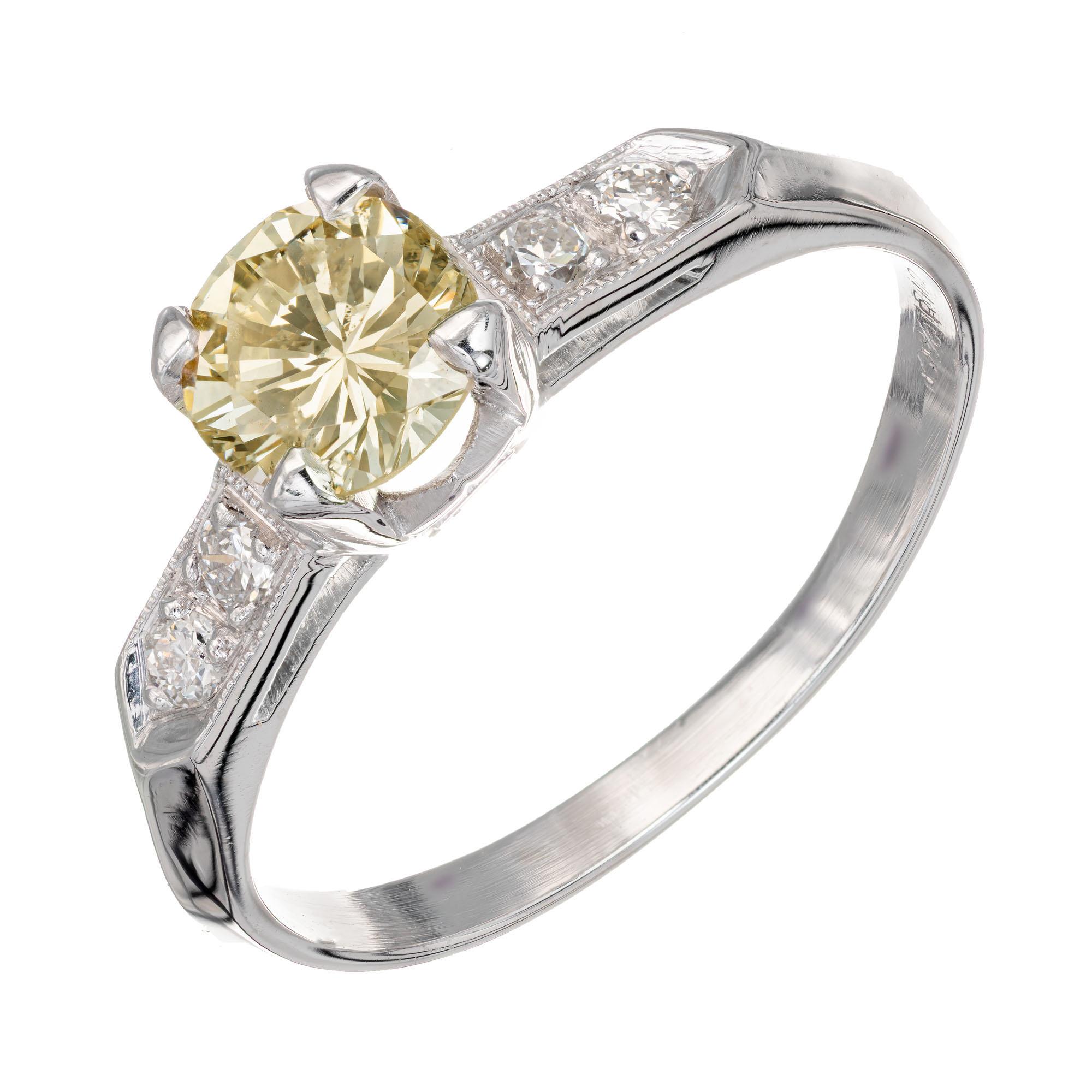 Vintage 1950's fancy natural light brownish yellow diamond ring. GIA Certified center stone with four round accent diamond in a platinum setting. 

1 round brilliant cut light brownish yellow diamond I, approx. .77ct GIA Certificate # 1206556636
4