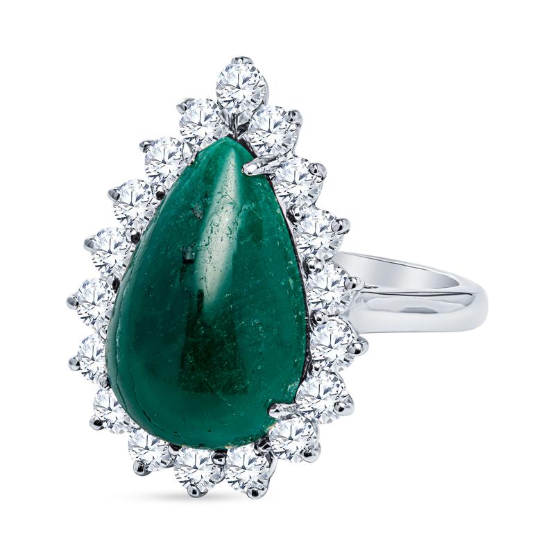 This ring features a 7.98 carat pear shaped cabochon natural emerald accented by a diamond halo of 1.65 carat total weight in round diamonds set in 14 karat white gold. It is a size 6.5 but can be resized upon request. This emerald has been