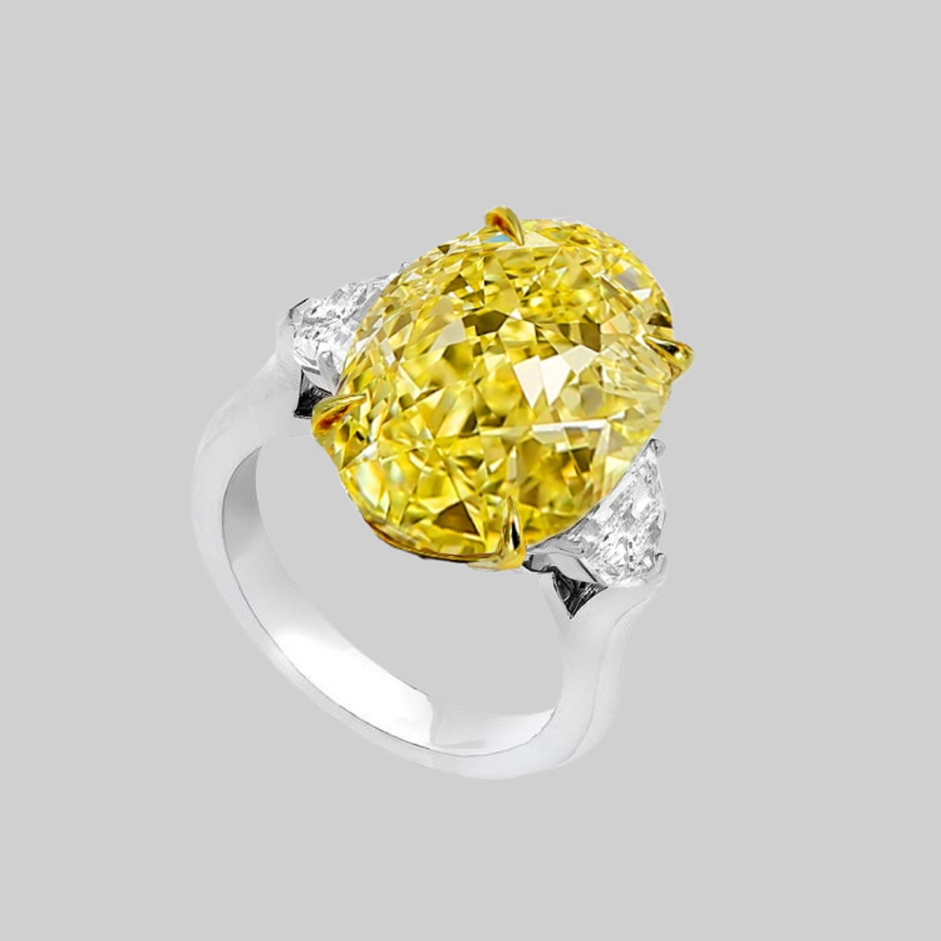 Un diamant ovale de 8 carats de couleur naturelle jaune intense, flanqué sur les côtés de deux diamants demi-lune de 1 carat au total, de couleur F, VVS2.  clarté. Les trois pierres sont certifiées par le GIA (voir les photos du certificat pour des