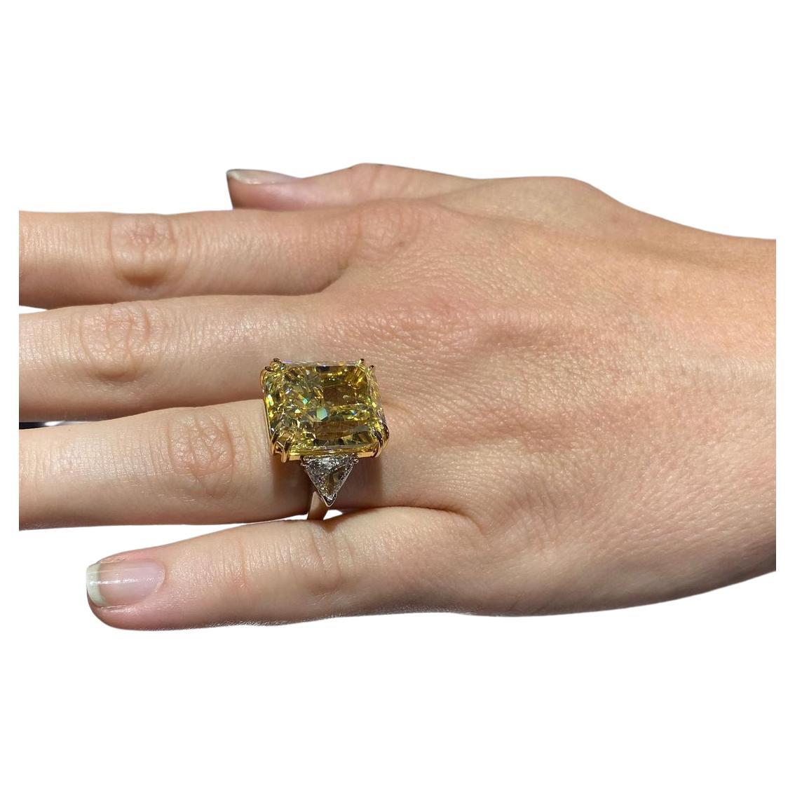 This magnificent engagement ring features a stunning 8 carat radiant-cut diamond, certified by GIA for its exceptional beauty. The center stone showcases a mesmerizing fancy yellow hue, exuding warmth and brilliance. 

With VS2 clarity, they are