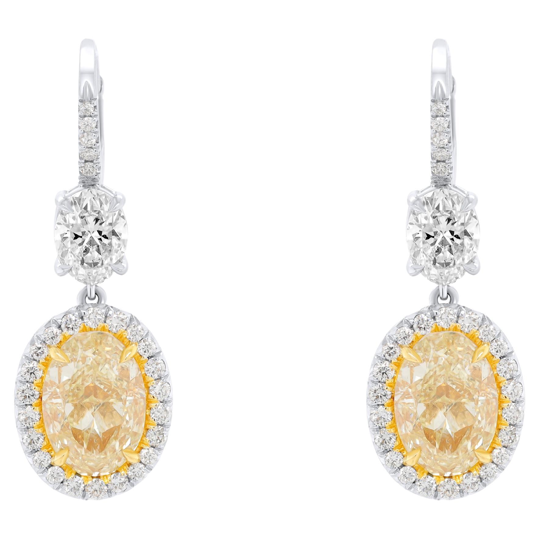 Fancy Yellow Oval Shaped Diamond Handing Earrings features total diamonds weight, each diamond is GIA Certified. 
These beautiful diamond earrings set in Platinum and 18K Yellow Gold, each diamond is 3.03 Carats Fancy Light Yellow SI2 in Clarity FUA