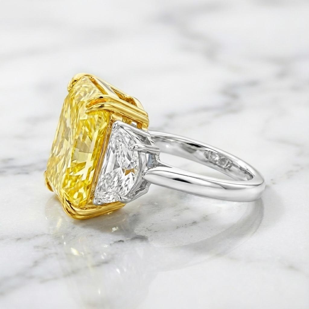 Cette bague exceptionnelle de haute joaillerie met en valeur un magnifique diamant certifié GIA de 8,01 carats de couleur jaune intense, classé VS1 avec une répartition uniforme des couleurs.
Taillée en forme de brillant modifié rectangulaire à