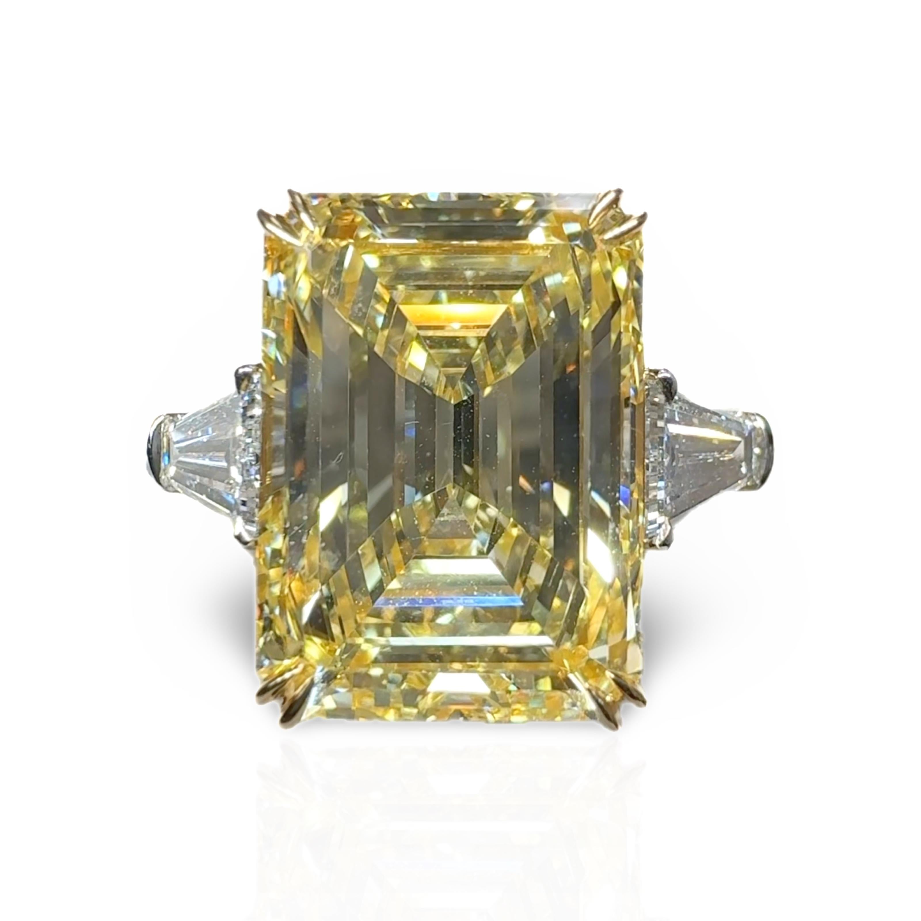 Ein aussagekräftiger Drei-Stein-Ring mit einem makellos geschliffenen natürlichen Fancy Yellow Emerald Cut Diamanten. 
Smaragdschliffe gehören zu den seltensten Schliffen unter den Fancy-Diamanten und sind mit einem Verhältnis von Länge zu