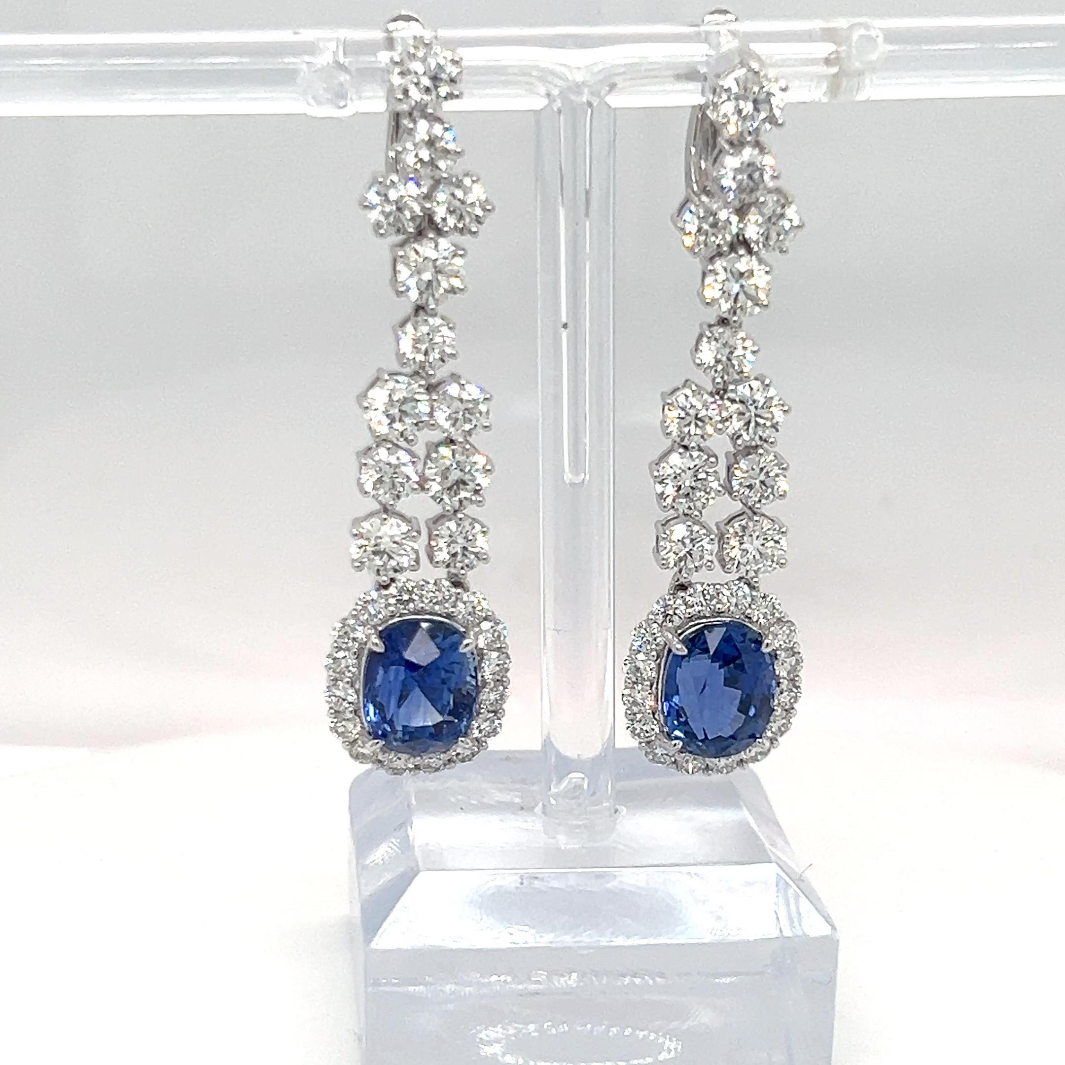 These GIA-certified 8.05-carat blue sapphire earrings feature stunning oval-cut sapphires, beautifully complemented by 6.52 carats of round diamonds to enhance their brilliance. Designed with a French back setting for a secure fit, these earrings