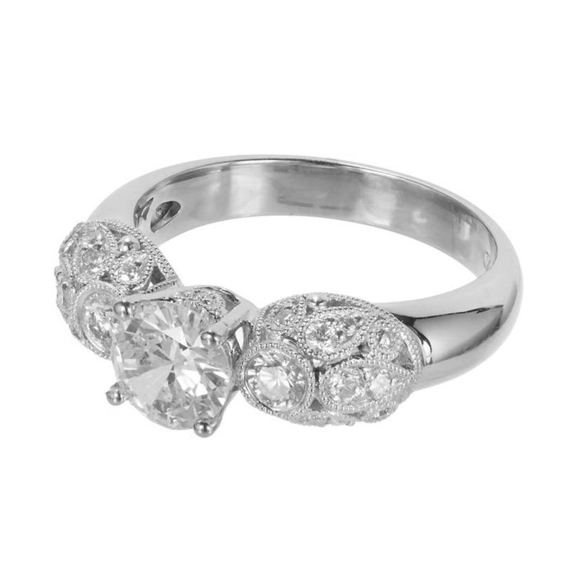 This exquisite engagement ring features a dazzling .81 carat GIA certified transitional cut diamond center stone that is nestled within a bed of 22 full cut shimmering pave diamonds in a unique 18k white gold   filigree setting with domed beaded