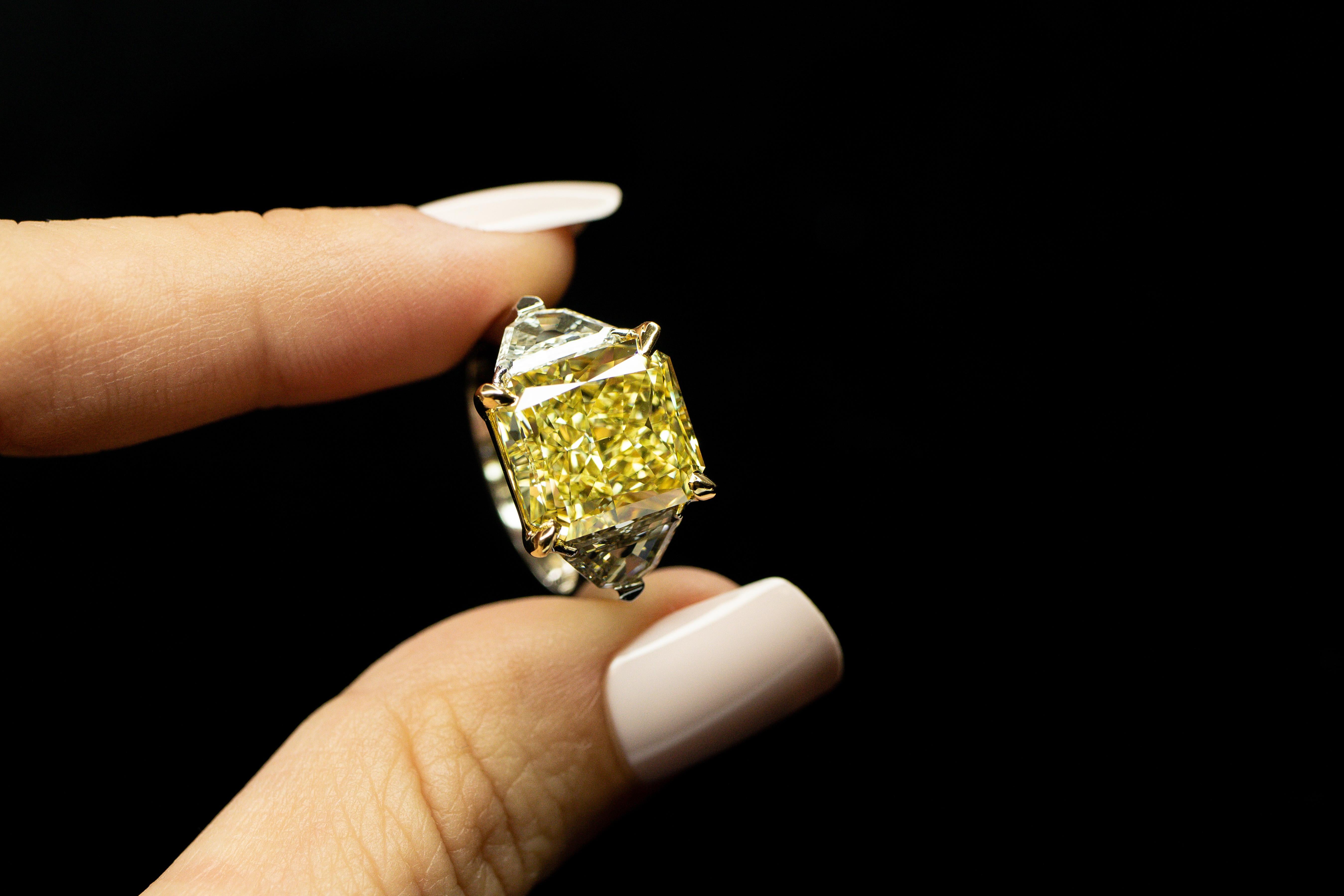 As yellow as the sun, a beautiful 8.11ct Radiant, Fancy Yellow, VVS2 Natural Diamond set in platinum & 18K yellow gold with 2 stunning Trapezoid cut natural diamonds=1.23cttw

This Diamond is GIA certified.