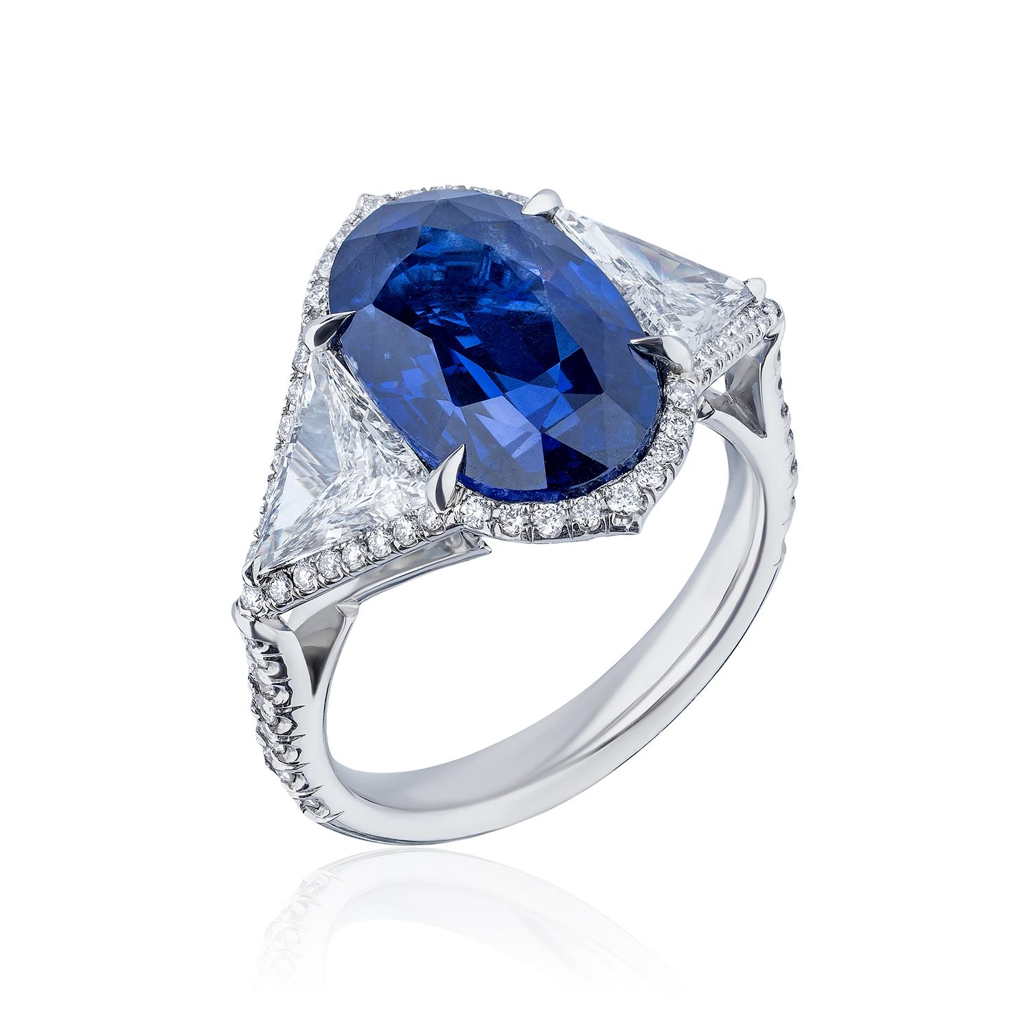 Centered upon a Oval Shaped Sapphire weighing 8.25 Carats and flanked by Triangle Diamonds, weighing 1.13 Carats of F color and VS Clarity. Further surrounded by 62 Round Brilliant Diamonds weighing 0.70 Carats.

Sapphire is certified by GIA as