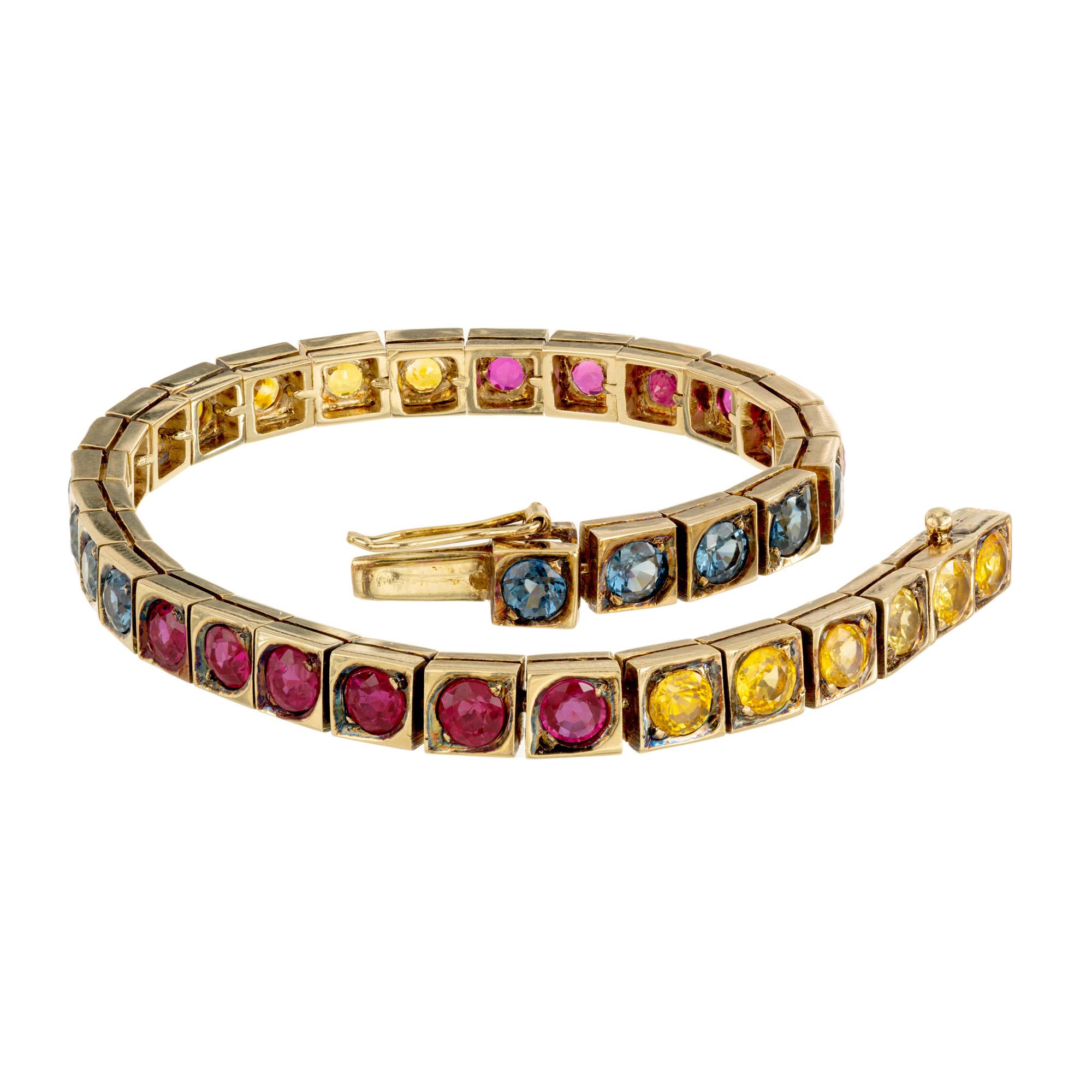 A cascade of vibrant colors with this GIA certified 8.25ct Ruby and Sapphire tennis bracelet. This exquisite piece is a harmonious blend of vibrant colors. Set with 9 blue and 12 yellow round sapphires along with 12 round rubies, mounted in a box