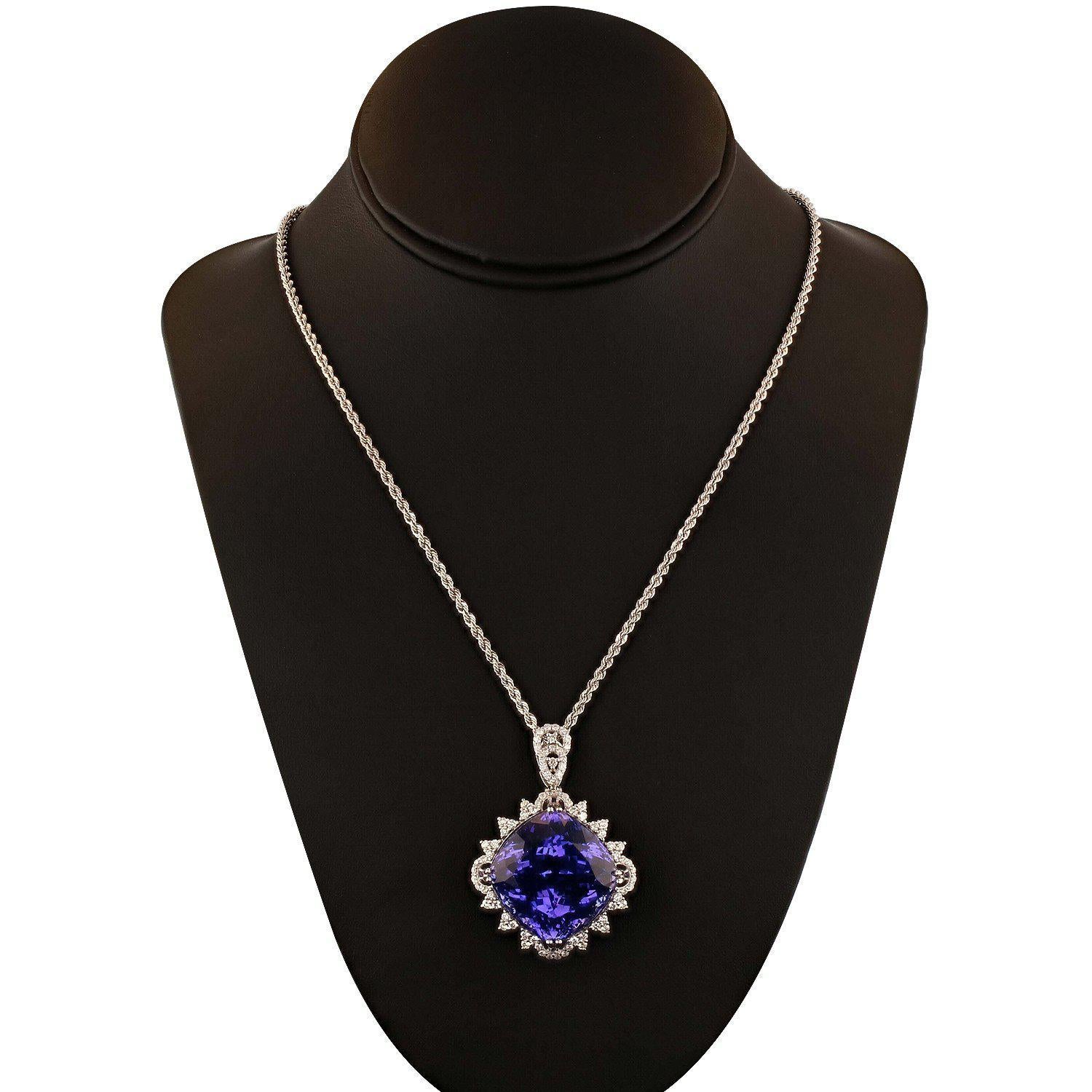 One electronically tested platinum ladies cast & assembled tanzanite & diamond pendant with chain. Condition is new, good workmanship. The pendant features a tanzanite set within a floret of diamond clusters, supported by a lattice under gallery,