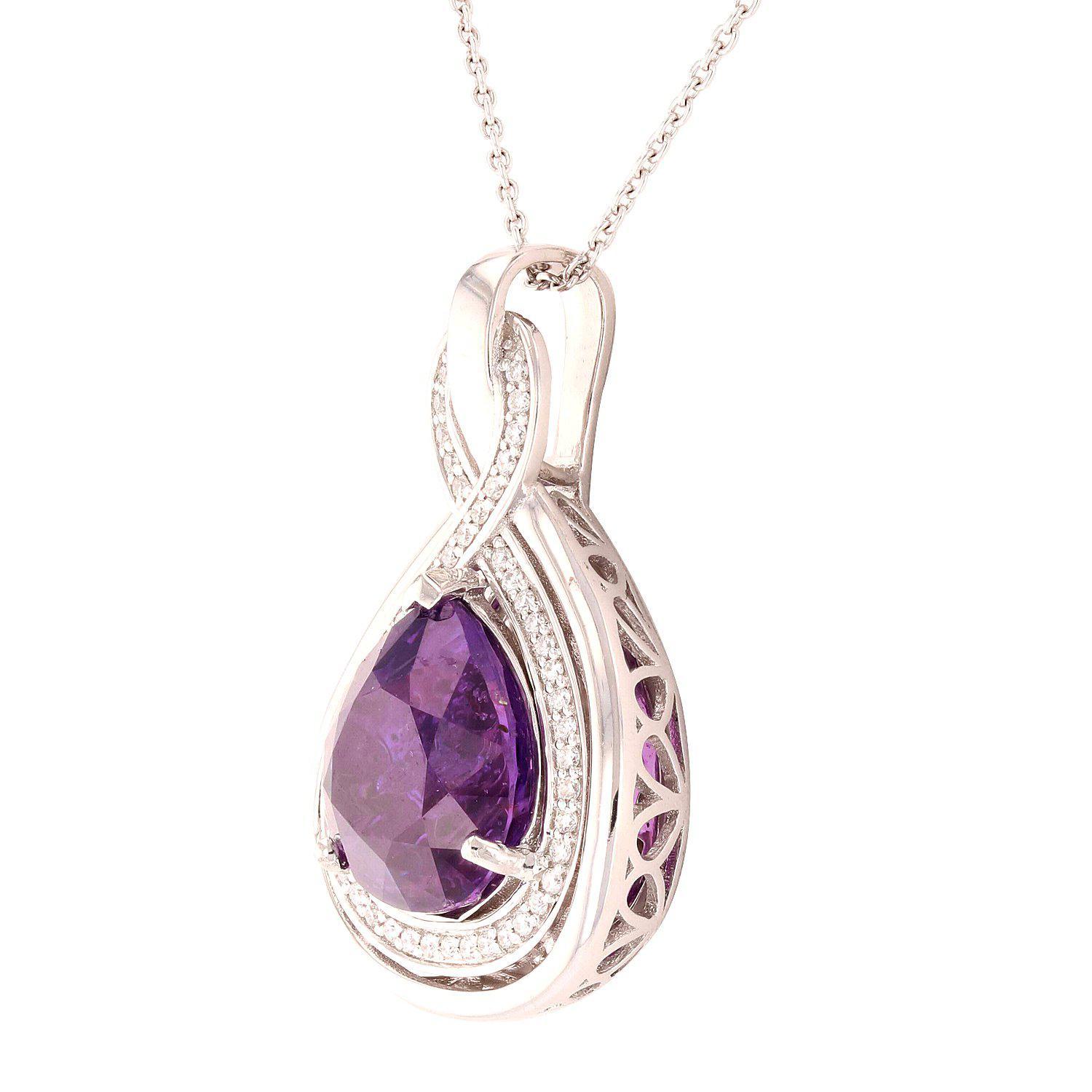 One electronically tested platinum ladies cast & assembled purple sapphire and diamond pendant with chain. Condition is new, good workmanship. The pendant features a purple sapphire set within a stylized diamond bezel, completed by a diamond set