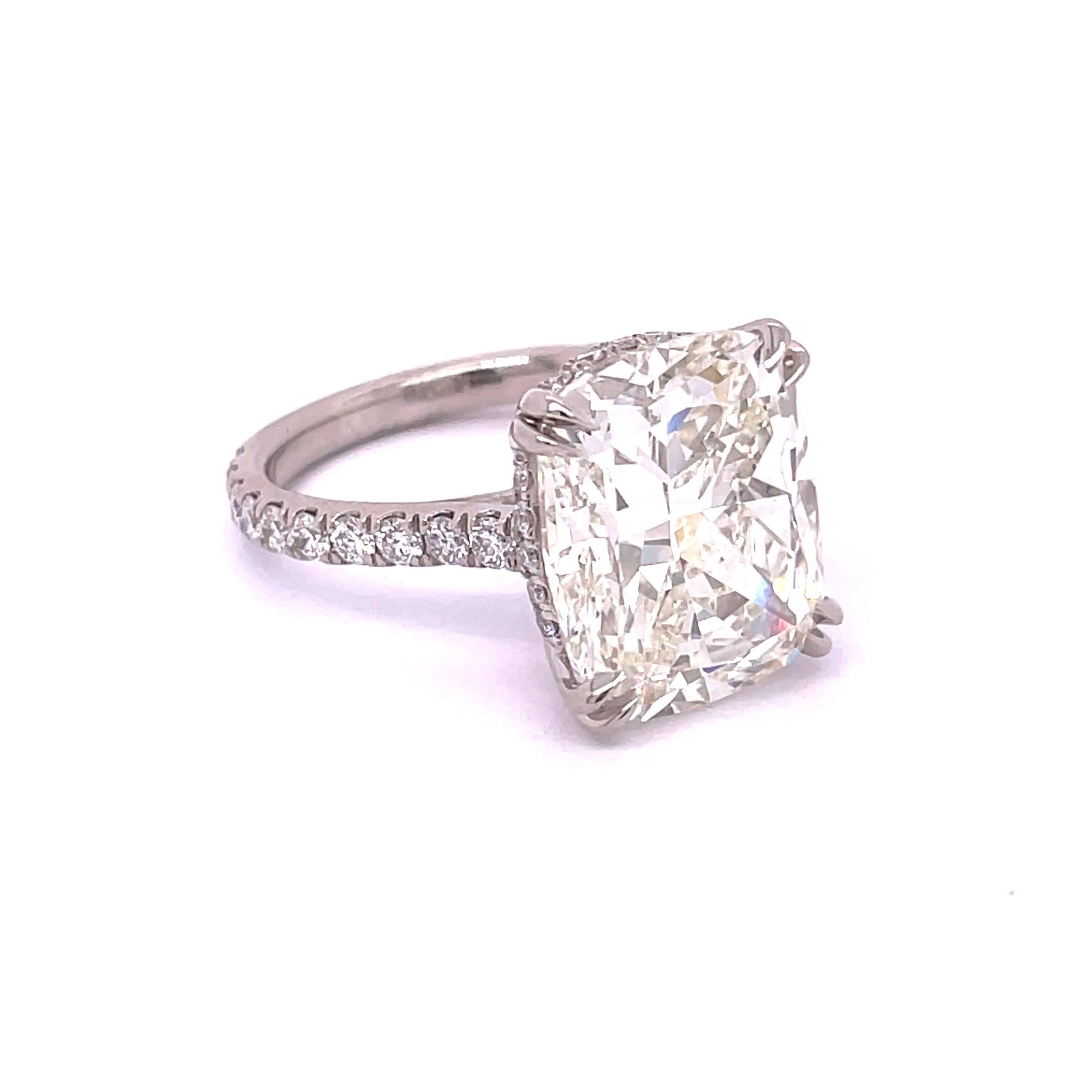 GIA Certified Cushion Shape Cut Diamond 8.58, J Color VS2 Clarity lays on a beautiful Platinum mounting with claw prongs holding it. Also, adding 0.86 carat round diamonds on to the shank blended with the brilliance of the center stone. Made to