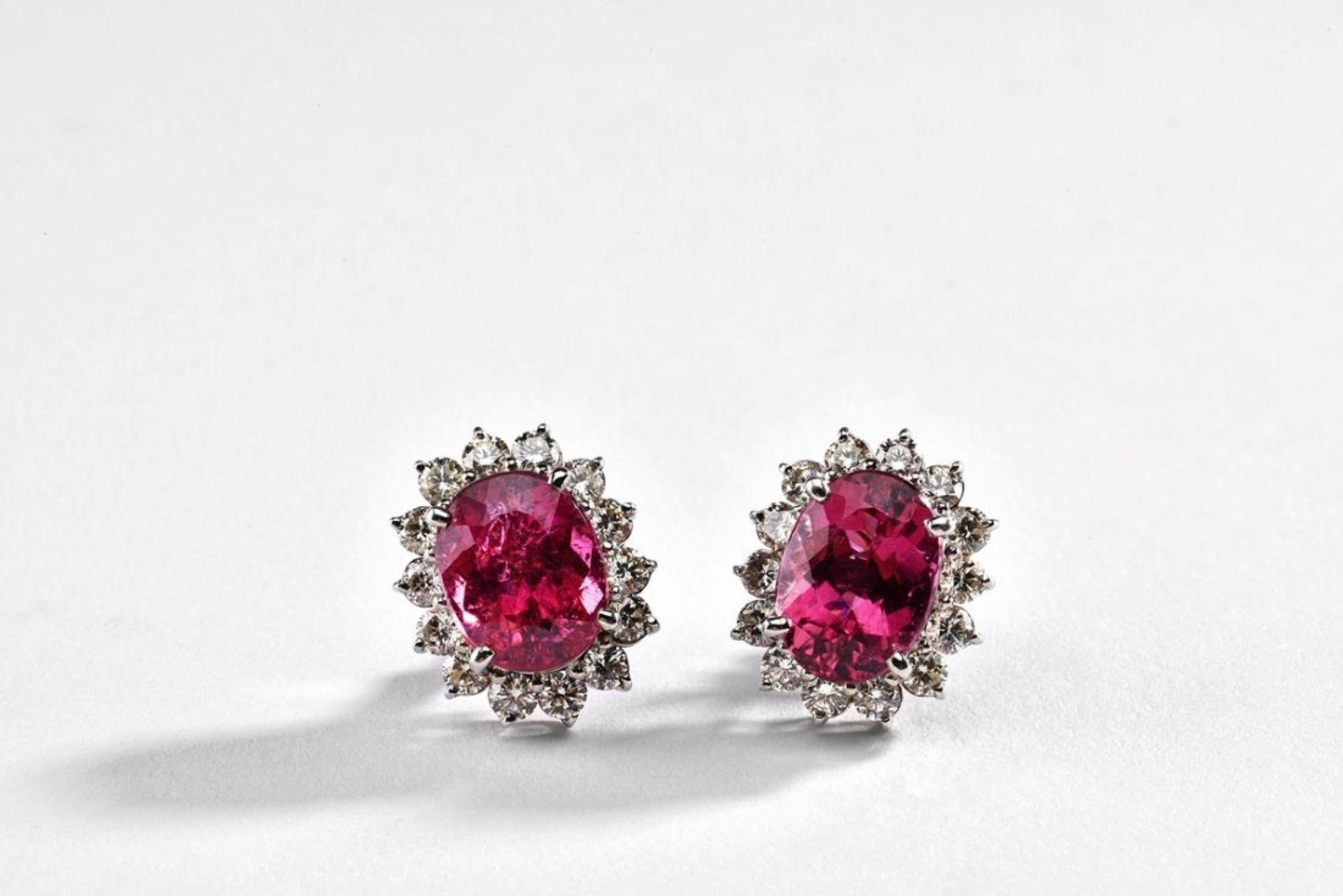 Chaque boucle d'oreille est centrée sur une tourmaline ovale naturelle de couleur rouge pourpre - connue dans le commerce sous le nom de rubellite - d'un poids total d'environ 8,63 carats. La rubellite mesure environ 11,81 x 8,60 x 6,03 mm et est