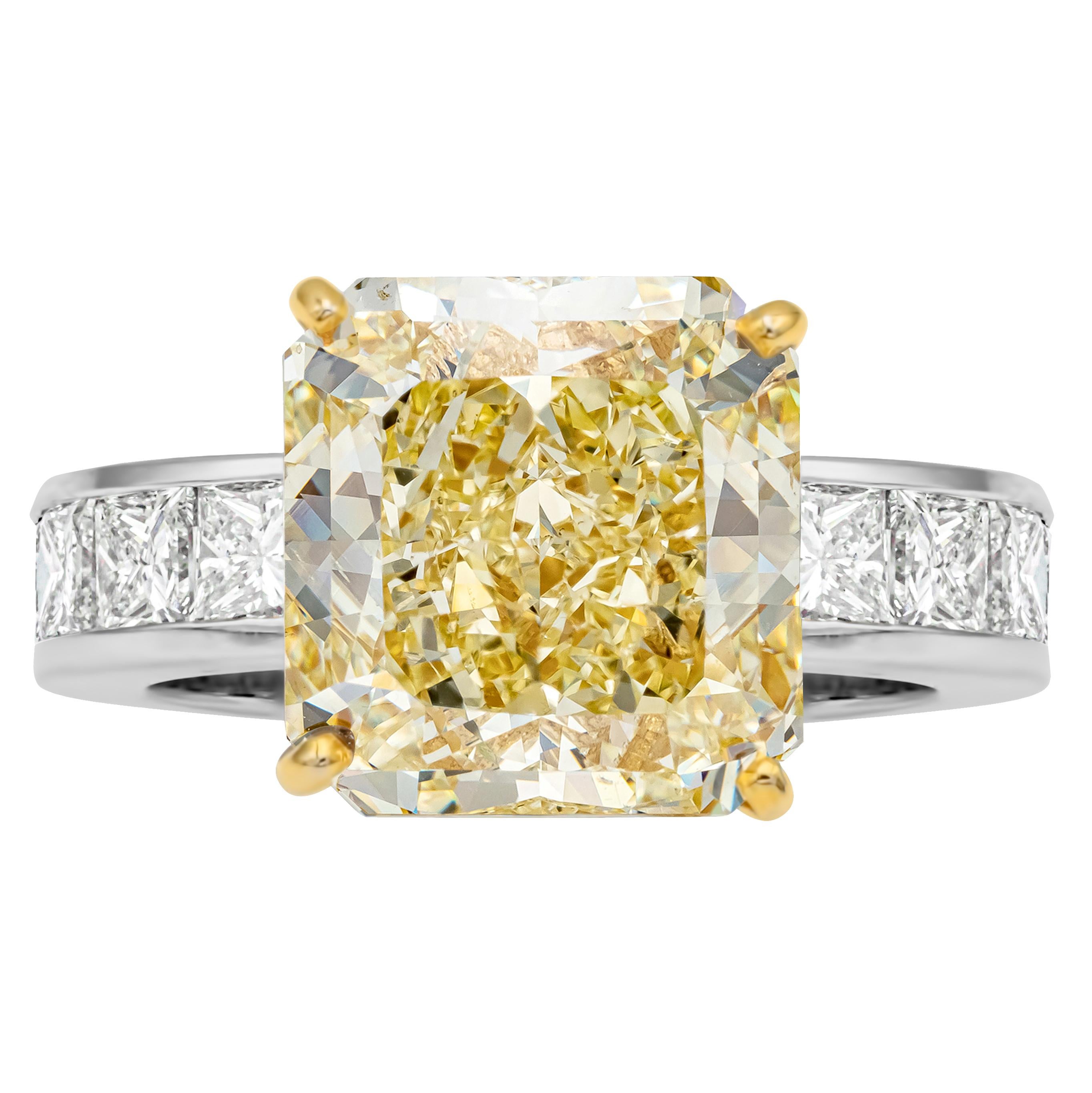 This classic and timeless engagement ring features a GIA Certified radiant cut center stone weighing 9.36 carats total, Fancy Yellow color and VS2 in Clarity, securely set in a four prong setting in 18K Yellow Gold. Accented by princess cut diamonds
