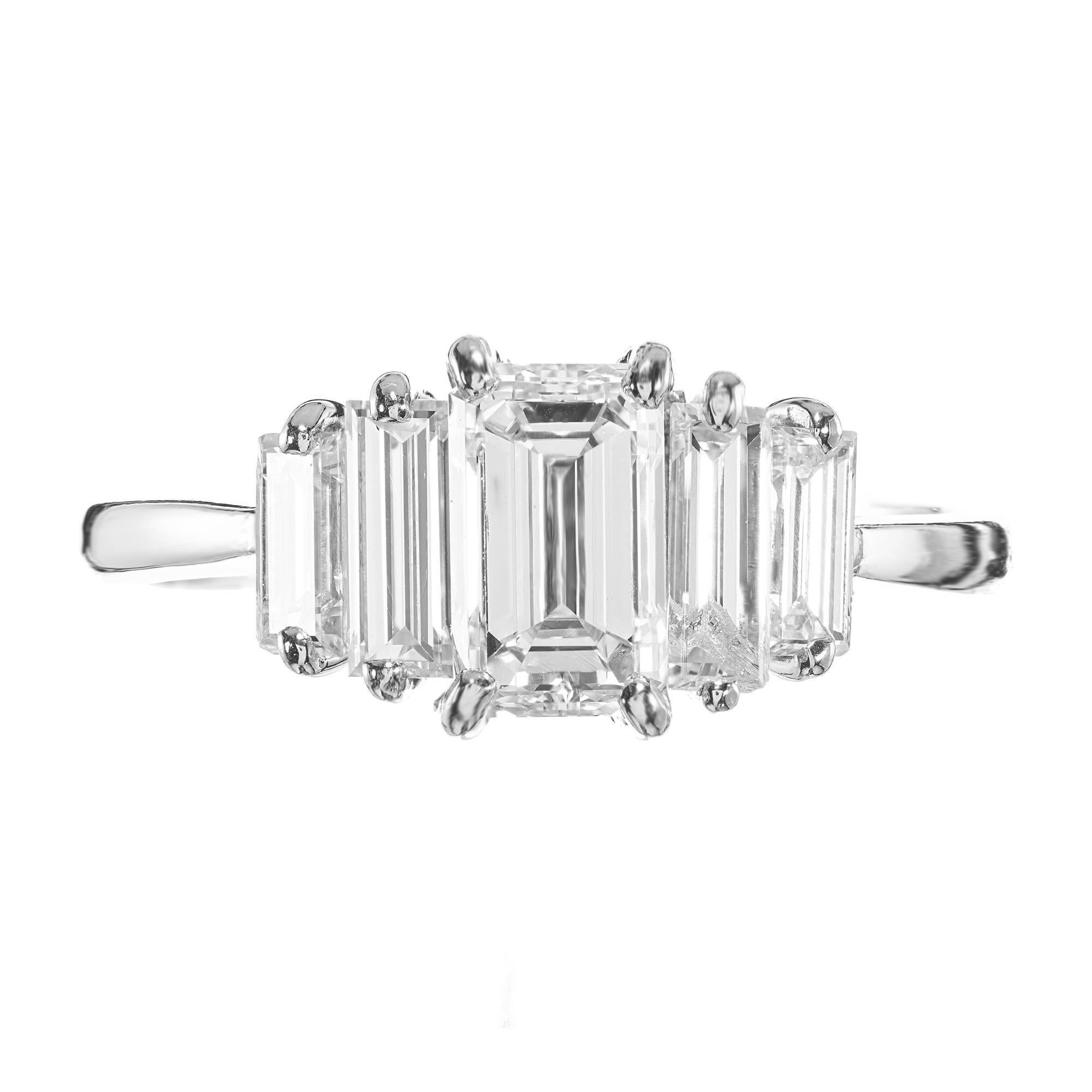 Captivating .94 carat emerald cut diamond accented by 2 baguette side diamonds, which are mounted in a  custom platinum five-stone handmade setting circa 1980’s. This stunning ring is very interestingly made with a total of 5 stones giving the
