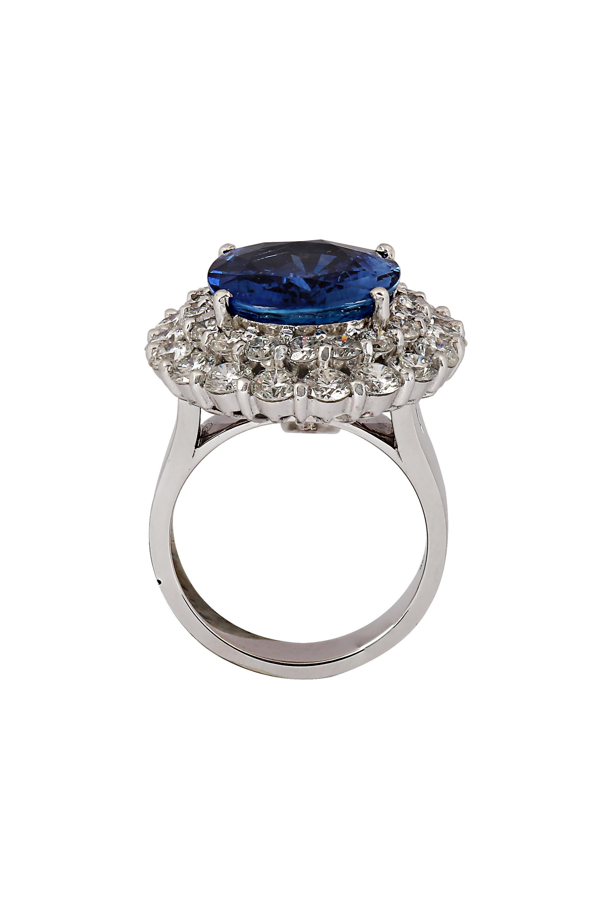 This extraordinary piece is a stunning blend of elegance and versatility. Featuring a 9.43 carat natural blue sapphire, the stone dazzles with its bright, crystalline brilliance. The sapphire is surrounded by a double halo of sparkling round