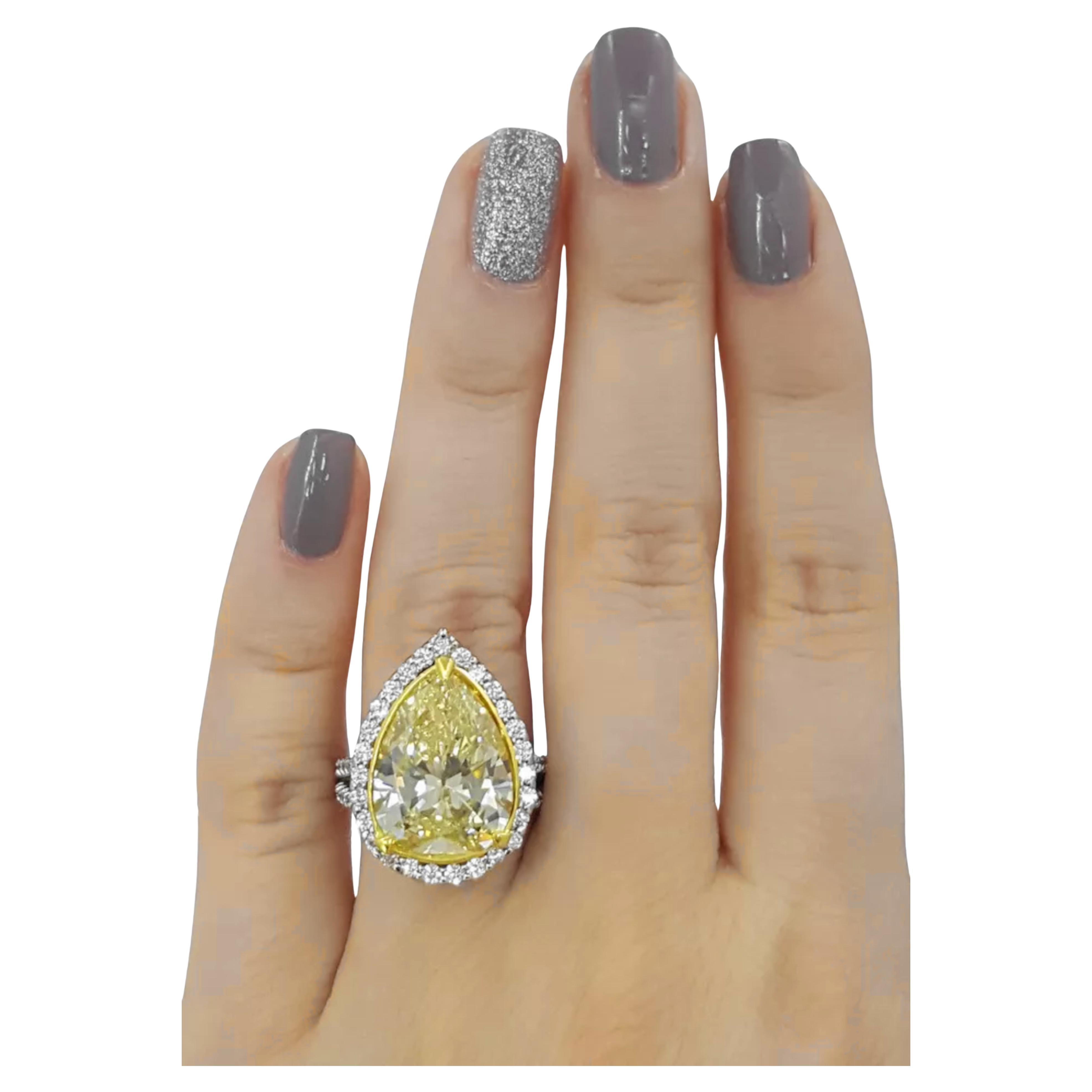 9.46 ct total weight engagement ring features an eye-catching design crafted in 18K white and yellow gold. The centerpiece is a 7.96 ct pear brilliant cut natural diamond, colored fancy yellow, and graded SI2 in clarity. It exhibits very good polish