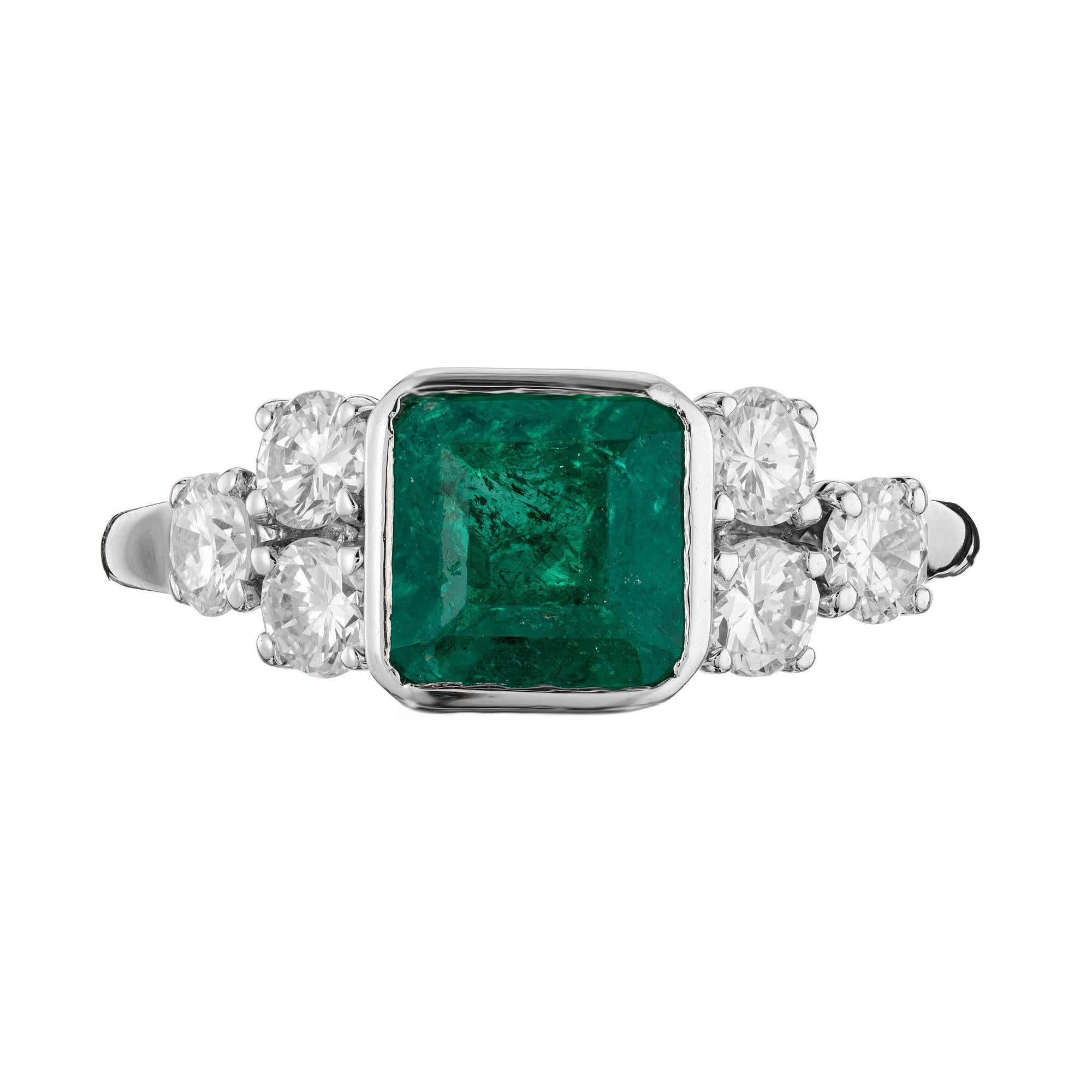 Rich emerald and diamond engagement ring. Exquisite square cut .95ct emerald mounted in a bezel setting. Accented with 3 round brilliant cut diamonds on each side. 14k white gold setting. The GIA has certified the emerald as natural with minor