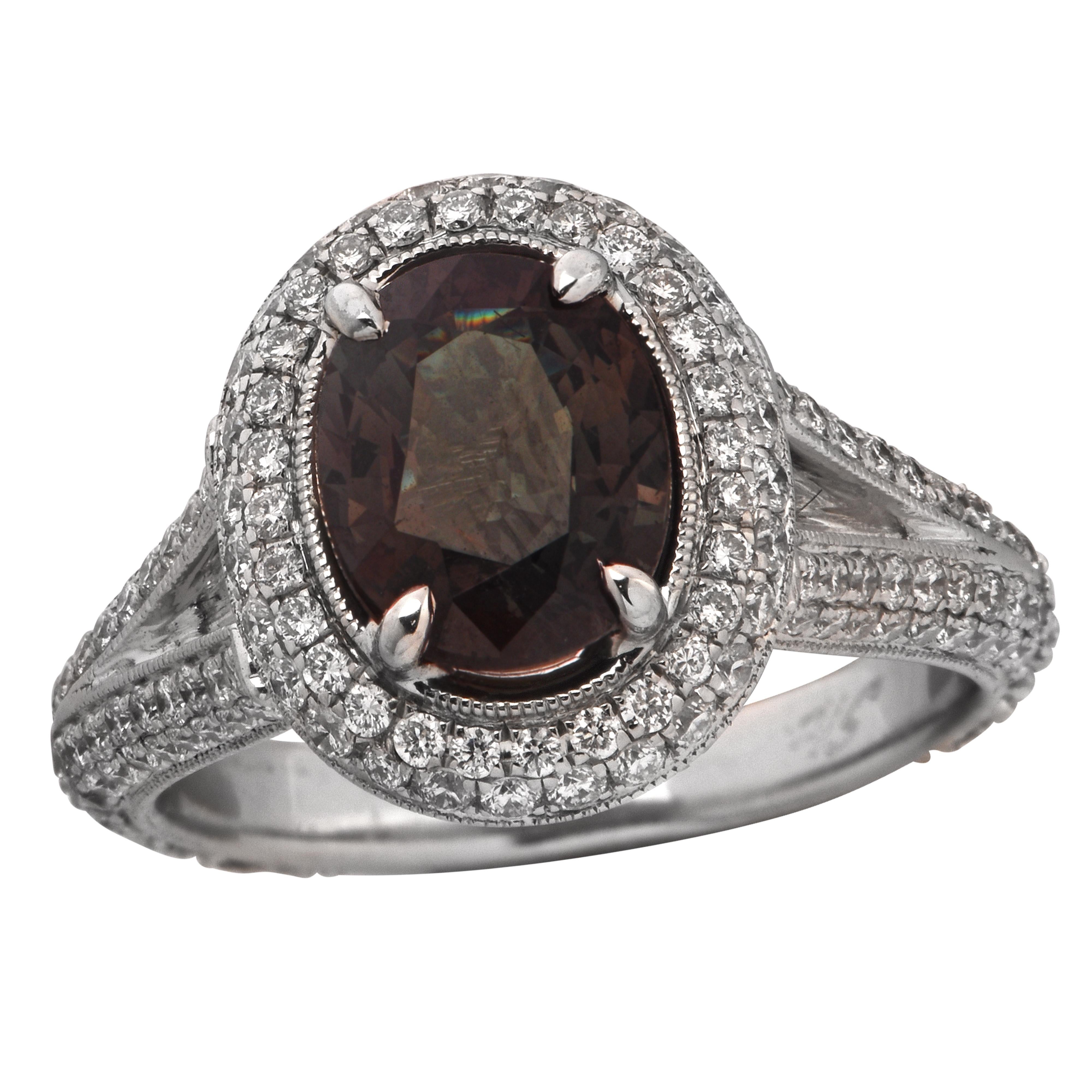Stunning custom-made ringd crafted in 18 karat white gold, showcasing a GIA certified oval cut Alexandrite weighing 1.67 carats, changing color from green to brownish purple, and approximately 1 carat total of round brilliant cut diamonds G color VS