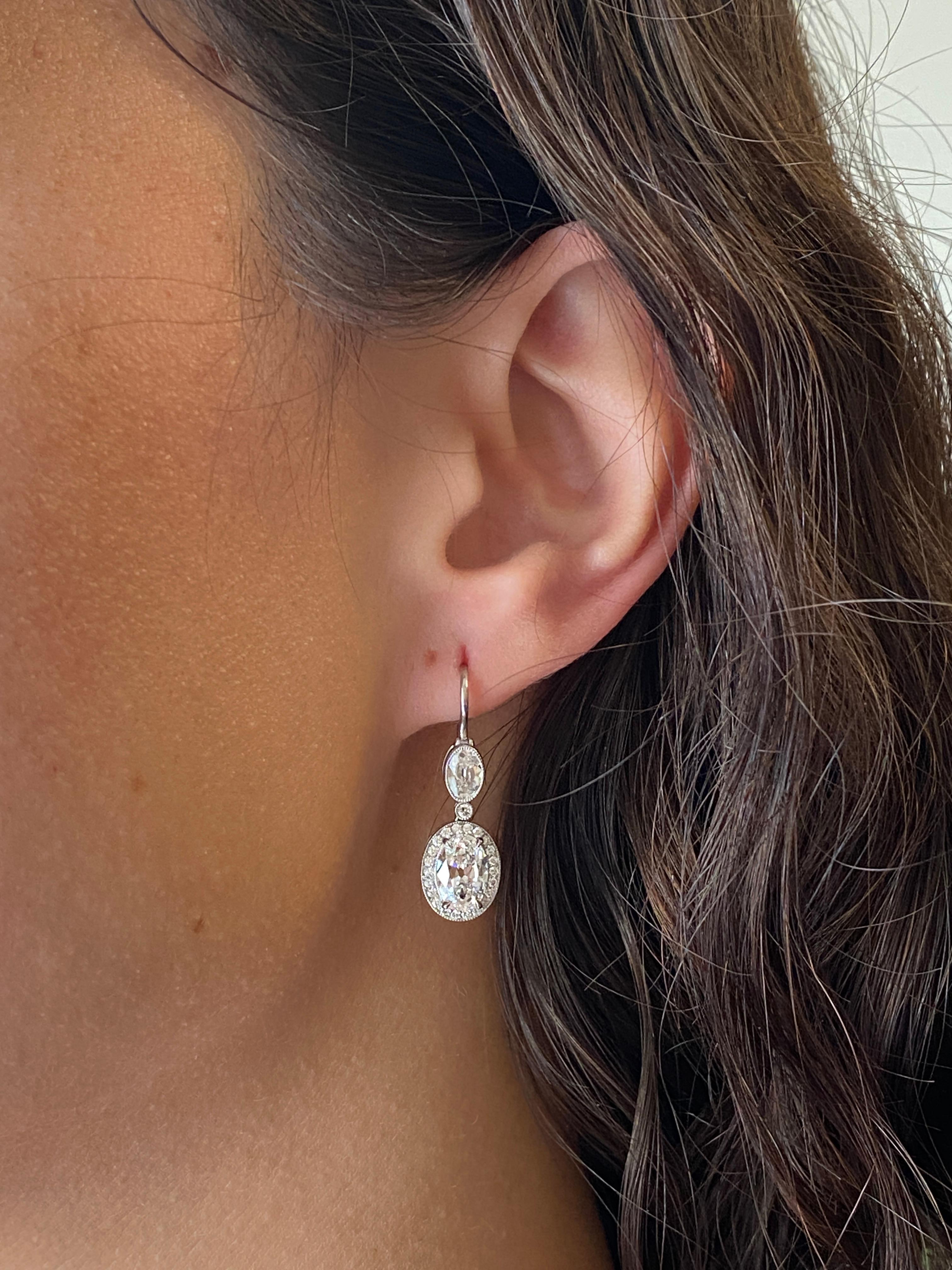 The stunning antique cut diamonds in these earrings are a testament to the craftsmanship and artistry of a bygone era, and highlight the unique beauty and character of antique diamonds. The two largest ovals weigh 1.01 carats each, and are certified