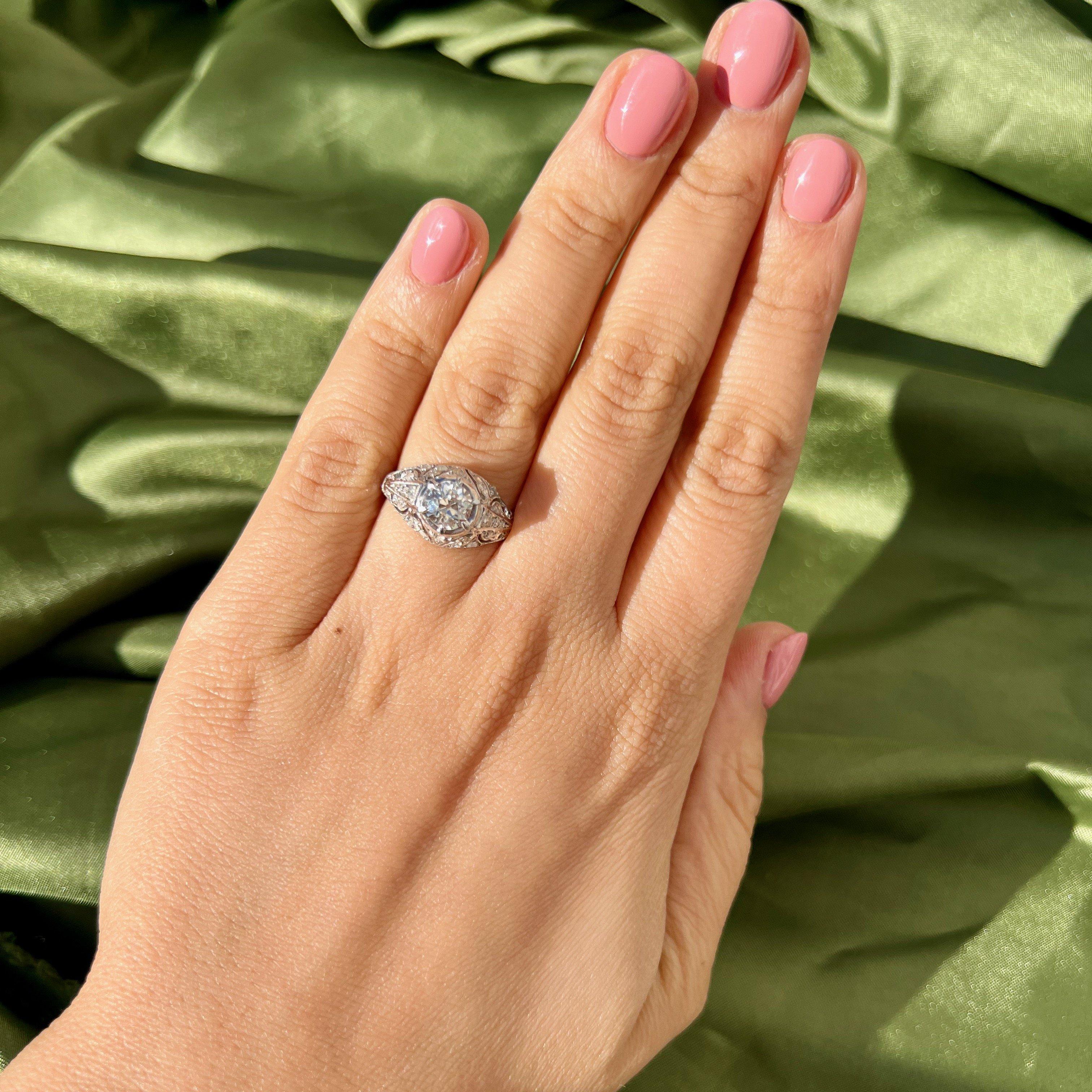 This art deco era ring checks all the boxes for us. It's centered by a beyond charming old mine cut diamond graded I SI2 by GIA. We love this cut for it's cushiony shape and blocky facets. The platinum crafted filigree setting, diamond studded, is