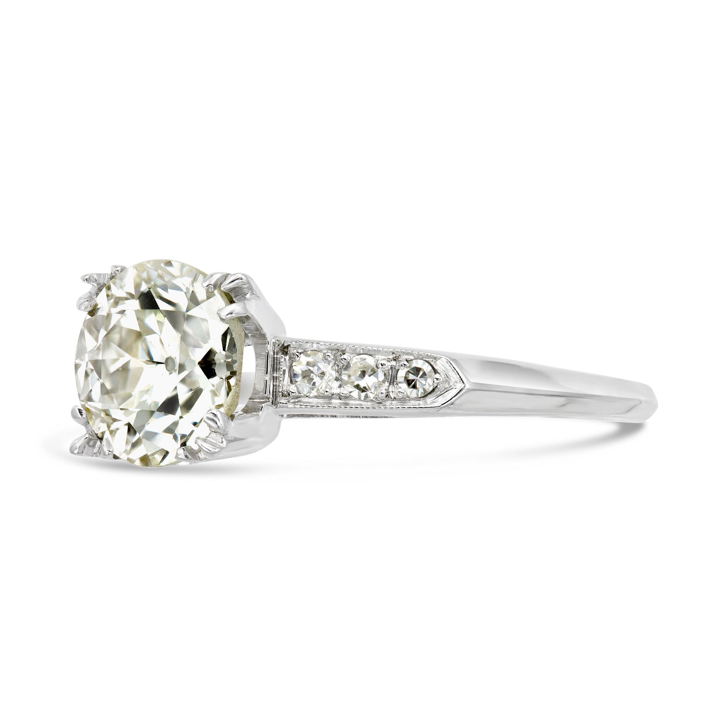This timeless art deco engagement ring is centered by a 1.78 carat old European diamond with crisp, beautiful facets that sparkle with every movement. All the classic elements of the deco era are present; milgrain shoulders, fishtail prongs, and a