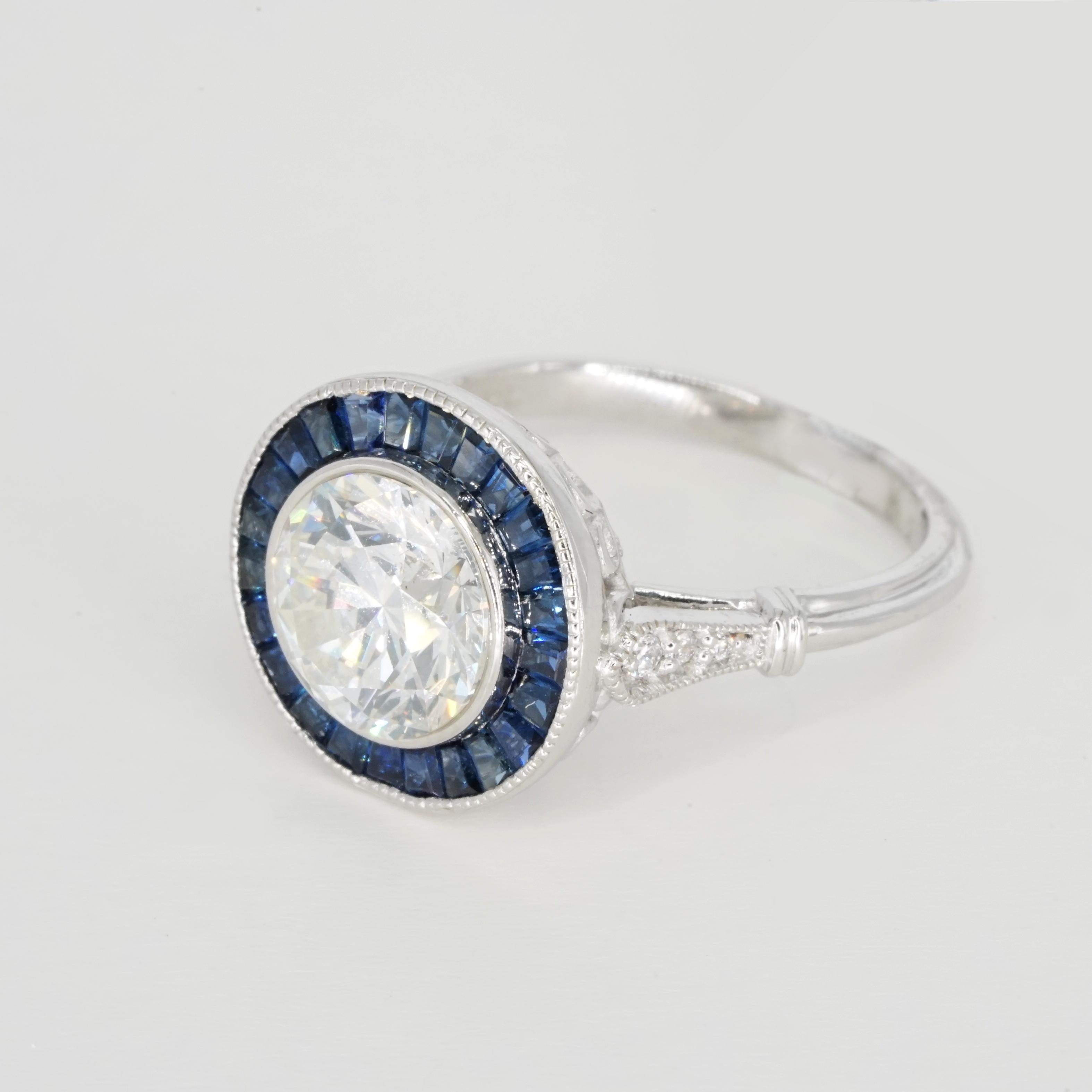 Art Deco style ring features a lively and substantial 2.20 diamond surrounded by a glamorous ring of royal blue natural sapphires. Certified by GIA with Excellent grades in all finishing categories, the diamond has fantastic brilliance! In a classic