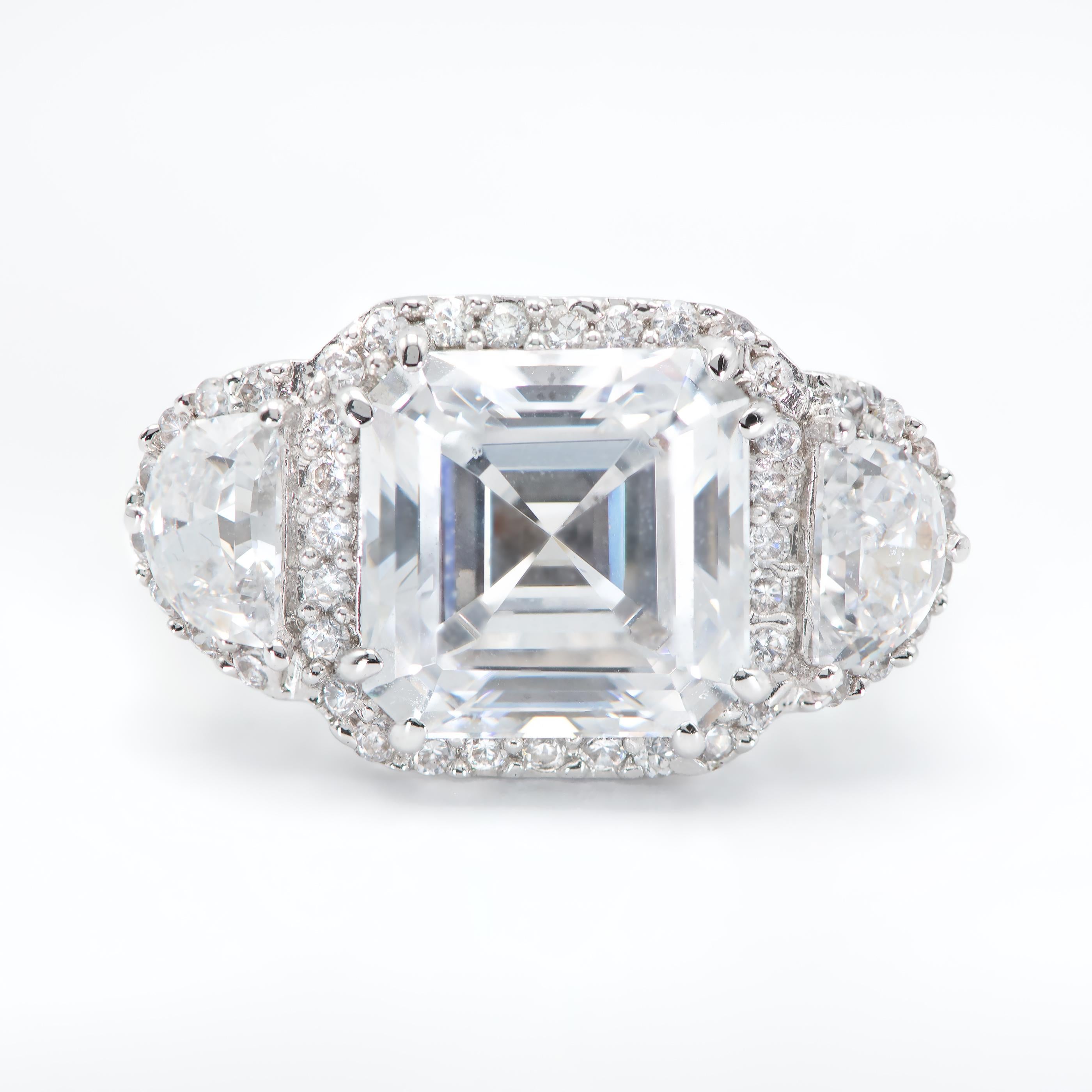Centered upon a 5 Carat GIA certified Asscher Cut Diamond of I color and VS2 Clarity, flanked by Half Moons weighing 0.80 Carats and surrounded by micro pave set Round Brilliant Diamonds.
Set in Platinum.
Size 6. Can be sized.
