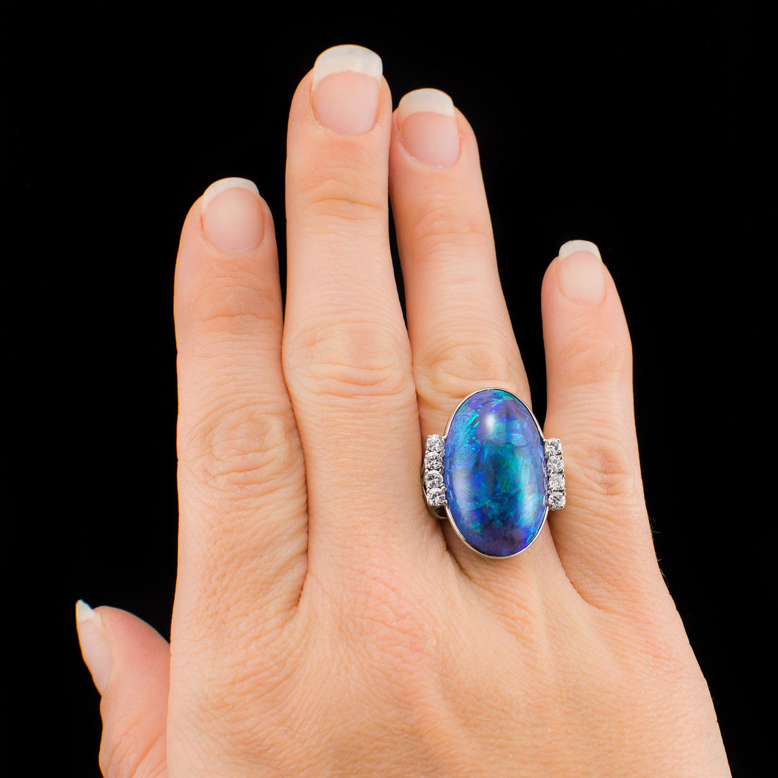 This is an exquisite Translucent Cabochon Black Opal Platinum Ring with GIA certification. This ring features a rare Translucent Black Opal displaying a stunning play of colors. The gorgeous opal measures 26.33 x 16.33 x 7.87 mm. with (8) Round