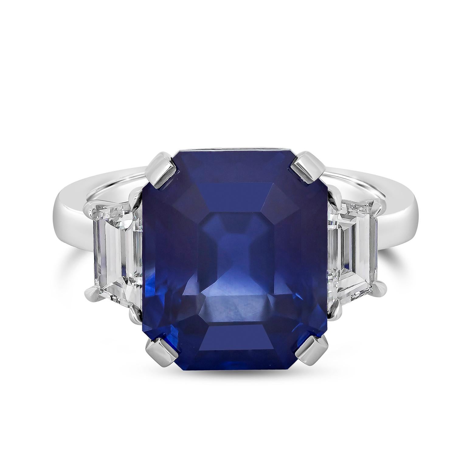 Showcasing an 8.99 carat GIA certified emerald cut blue sapphire, flanked by step-cut trapezoid diamonds, set in a polished platinum mounting. Accent diamonds are 0.76 carats total and are approximately E color, VS clarity. 

Style available in