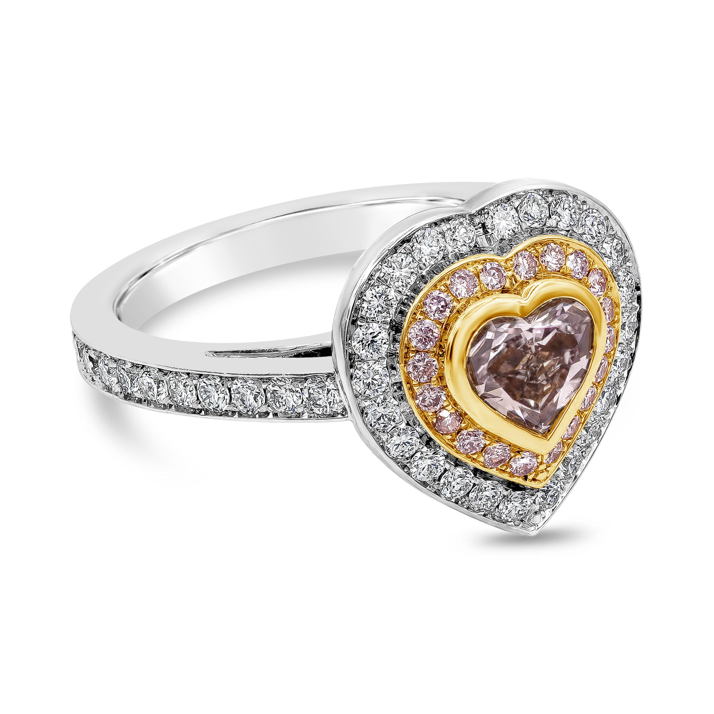 A wonderful engagement ring, showcasing a 0.75 carat heart shape diamond certified by GIA as Fancy Brownish Pink color and SI2 clarity, bezel-set on 18K yellow gold. Surrounded by a double halo of round brilliant cut pink diamonds weighing 0.12