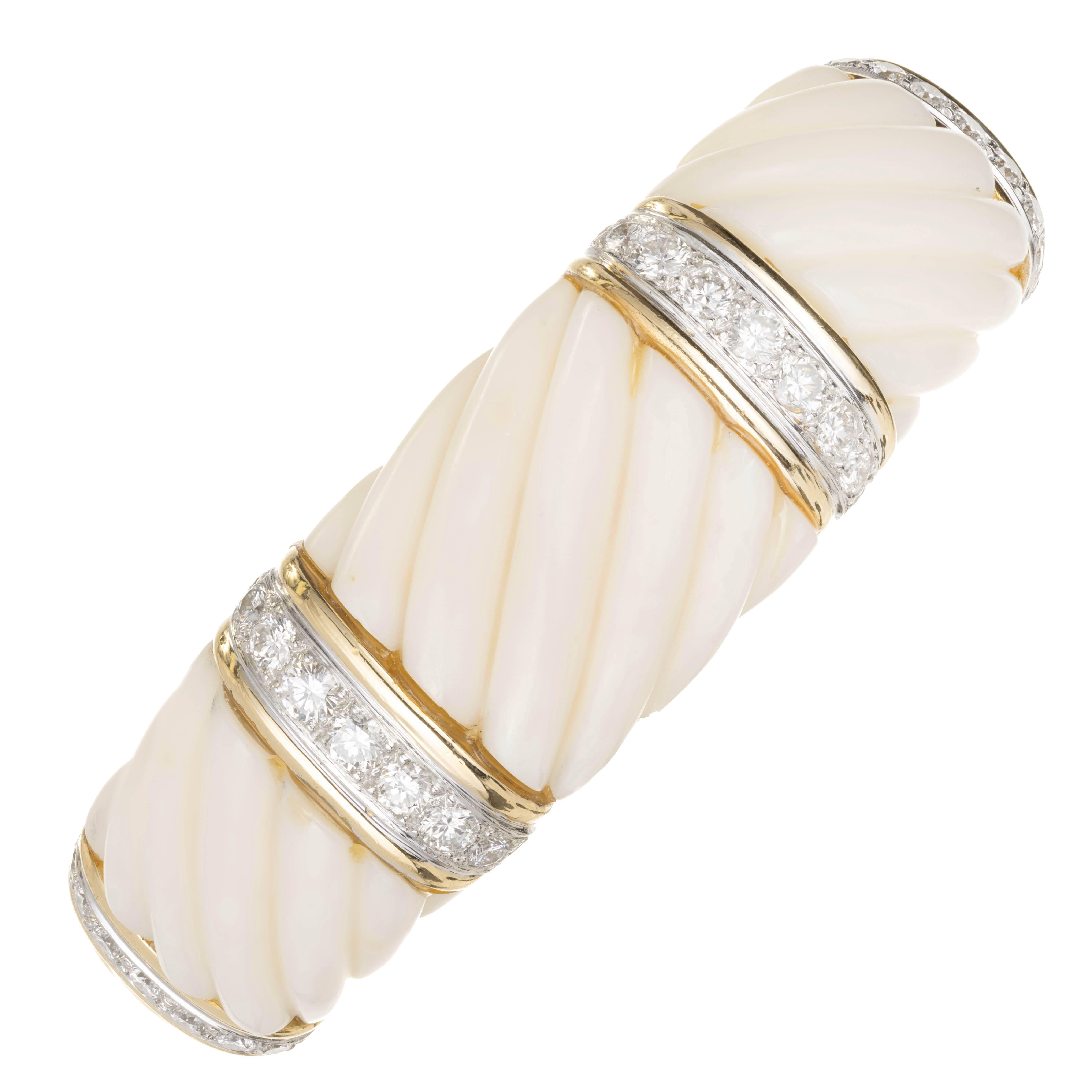 18k yellow gold open bangle with calcite and diamonds. Three sections of scalloped carver white calcite are separated by four rows of round brilliant cut diamonds set in 18k gold. The bottom of the open bangle is made of 18k yellow gold with the