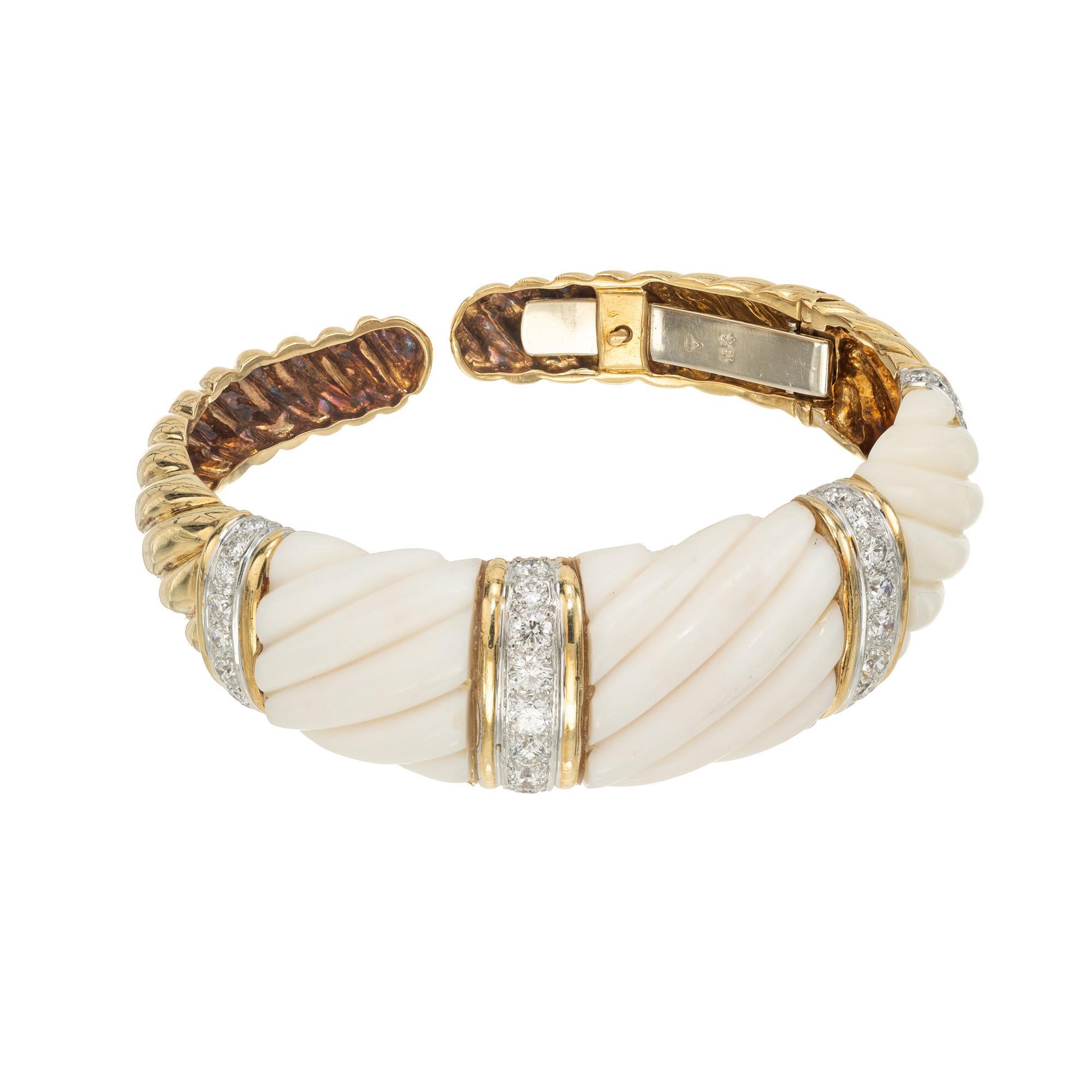 Bracciale aperto in oro giallo 18k con calcite e diamanti. Tre sezioni di calcite bianca smerlata sono separate da quattro file di diamanti rotondi taglio brillante incastonati in oro 18 carati. La parte inferiore del braccialetto aperto è in oro