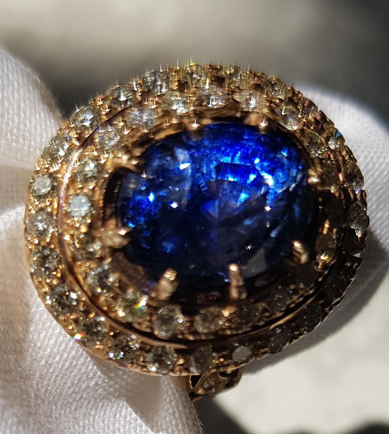 Claw-set with an ovel step-cut shaped  Ceylon No heated, No treated blue sapphire within a surrounded diamonds.
Since unheated Burma and Kashmir sapphires are becoming so difficult to obtain, it makes sense to diversify with other sources. Since