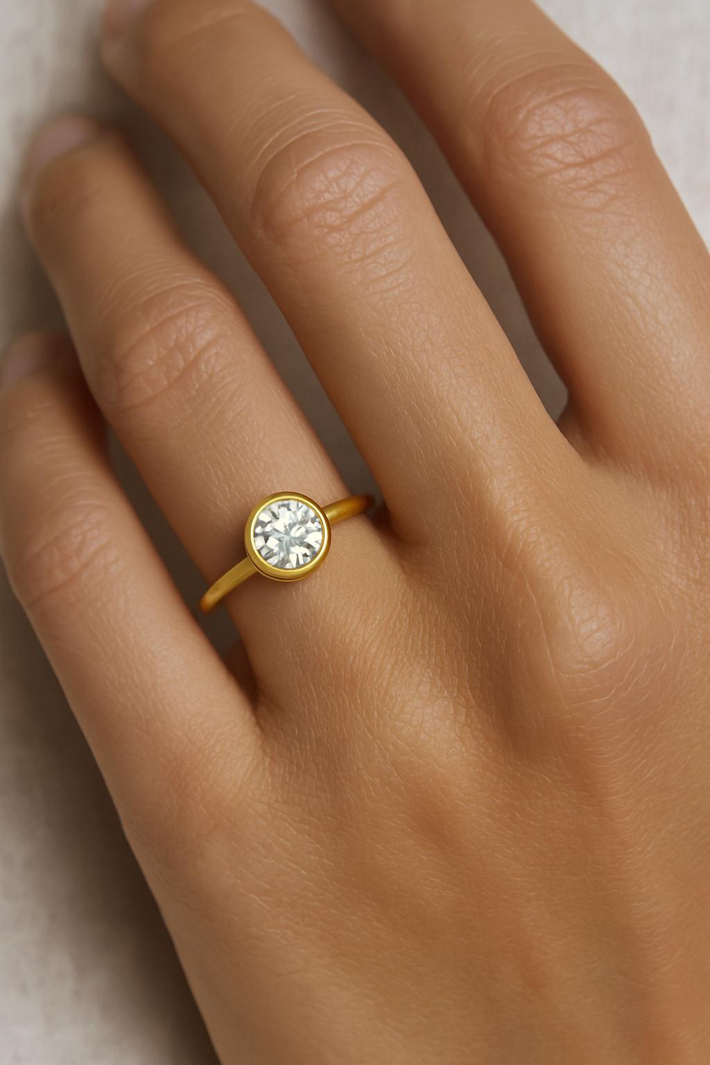 Questo anello solitario senza tempo mette in mostra un diamante tondo brillante da 1,07 carati, certificato GIA e classificato con colore da O a P e purezza SI1. Il diamante mostra una luce morbida e calda, sottile ed elegante, esaltata