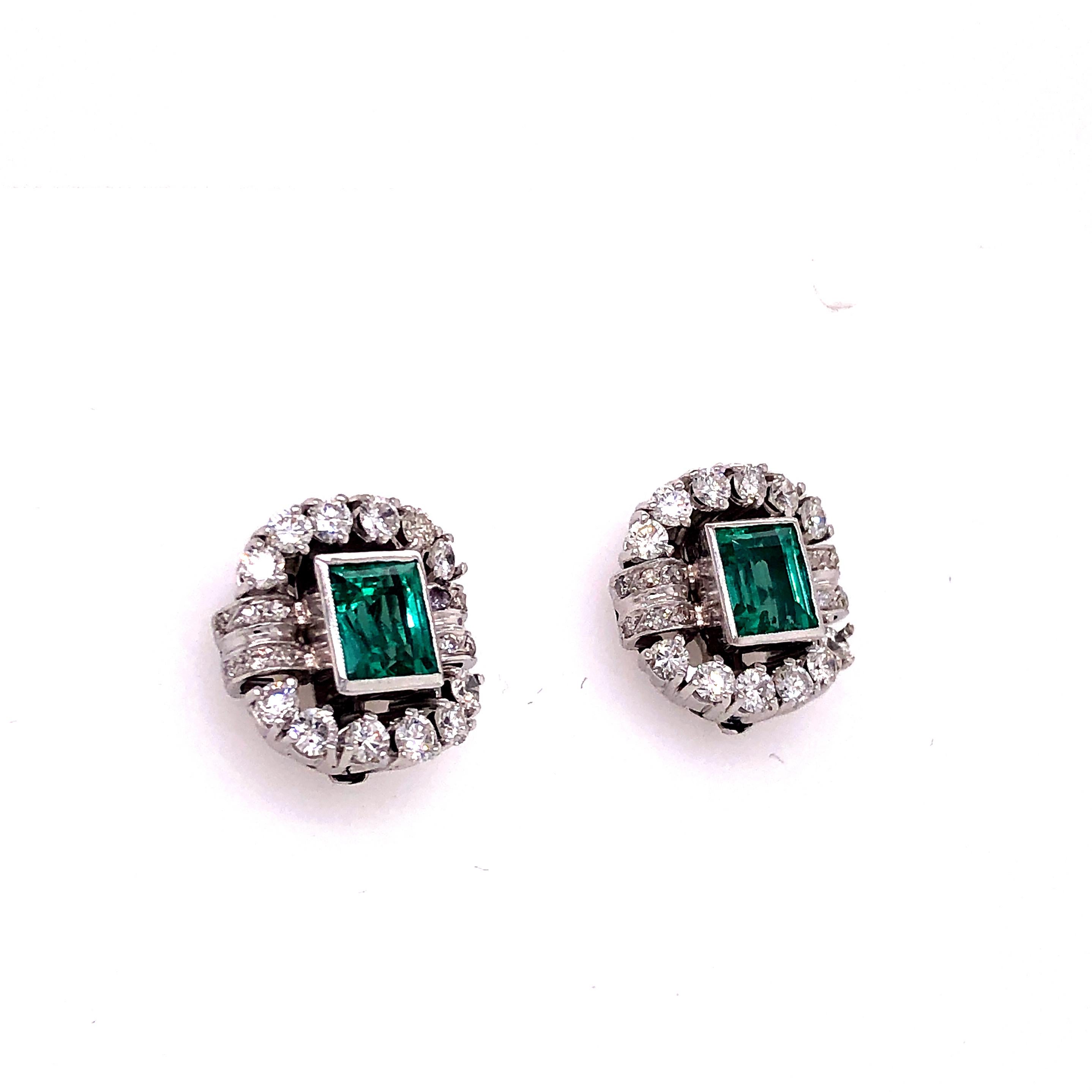 One of a kind beautiful pair of handmade platinum earrings. This vintage design shows two Columbian Emerald gemstones bezel set in a decorative natural Diamond mounting. The pair is accompanied by a G.I.A. certificate which indicates these gemstones