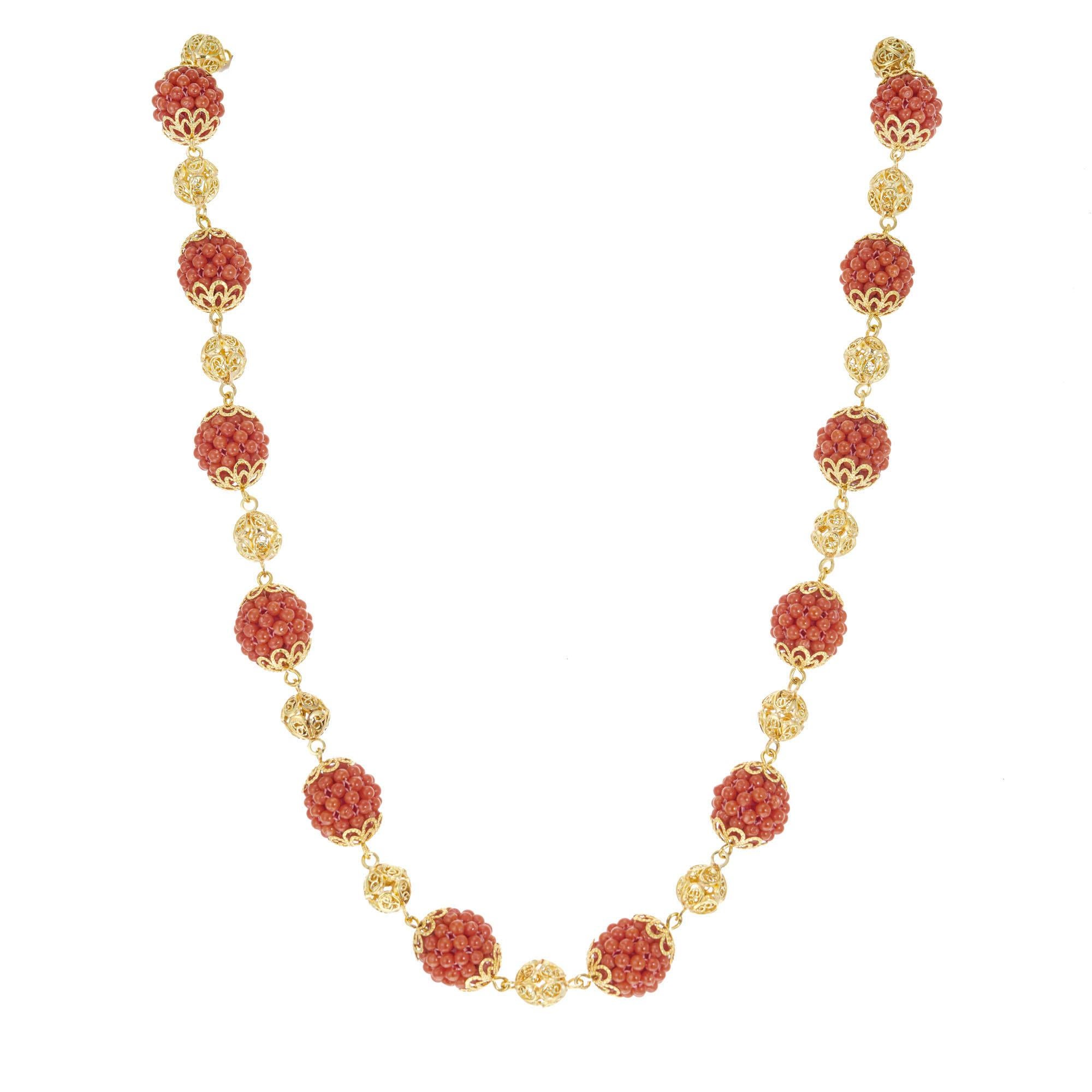 Vintage 1960's coral bead necklace with 16 sections of small GIA certified natural orange/red coral beads, spaced by open work yellow gold balls.  19.5 inches in length 

16 orangey red coral beaded balls, 2.7mm GIA Certificate # 6217688814
18k