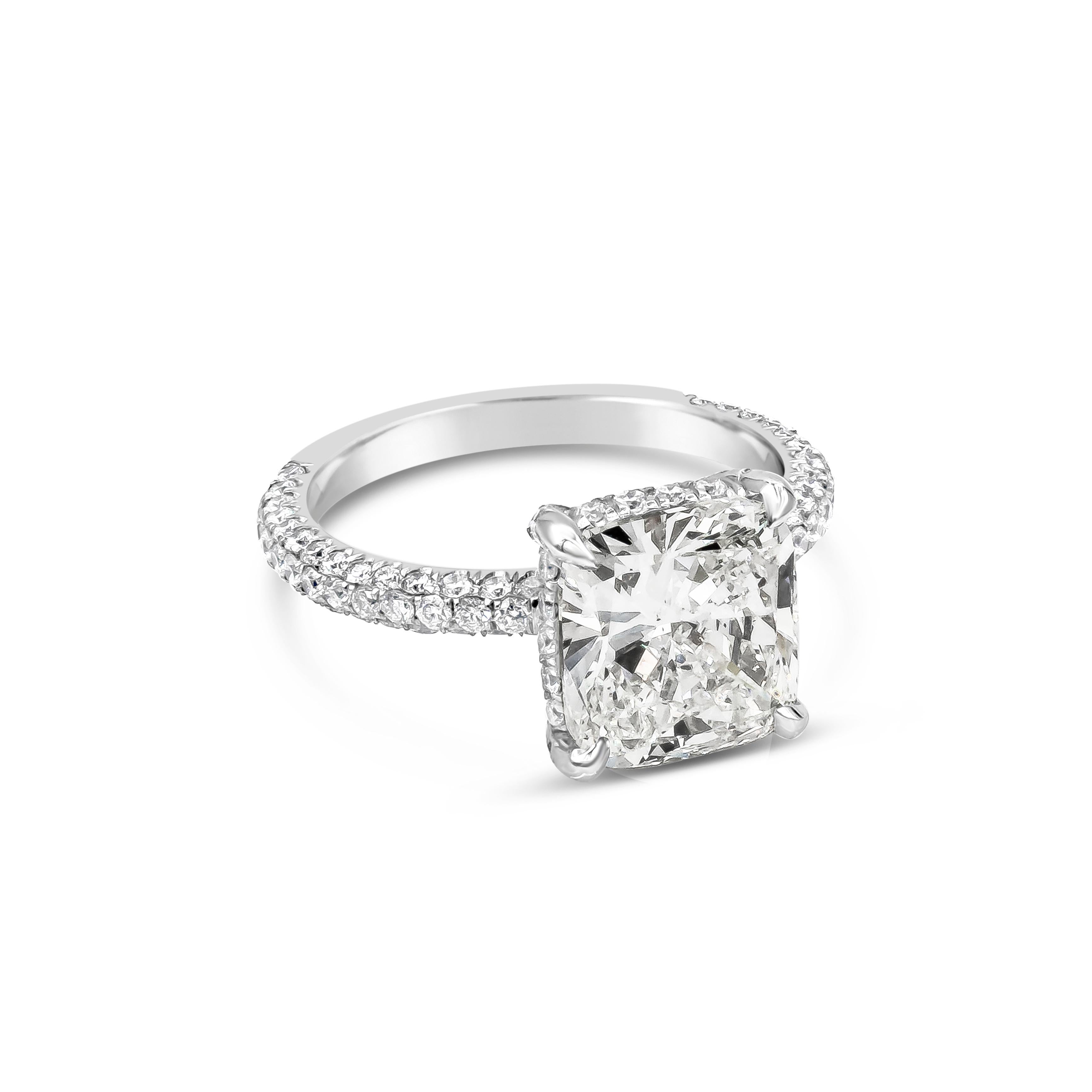 A brilliant engagement ring style showcasing a 3.08 carat cushion cut diamond, certified by GIA as J color, SI2 clarity, set in a diamond-encrusted basket; polished platinum band micro-pave set with round brilliant diamonds. Accent diamonds weigh
