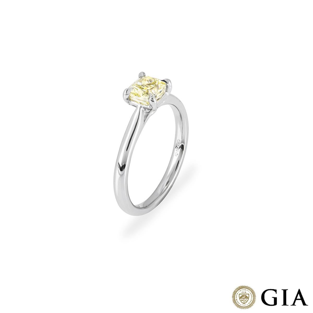 A platinum cushion cut fancy yellow diamond ring. The ring features a cushion cut diamond set to centre in a four claw setting. The diamond has a weight of 1.01ct with a fancy yellow colour with even distribution and SI1 clarity. The ring is