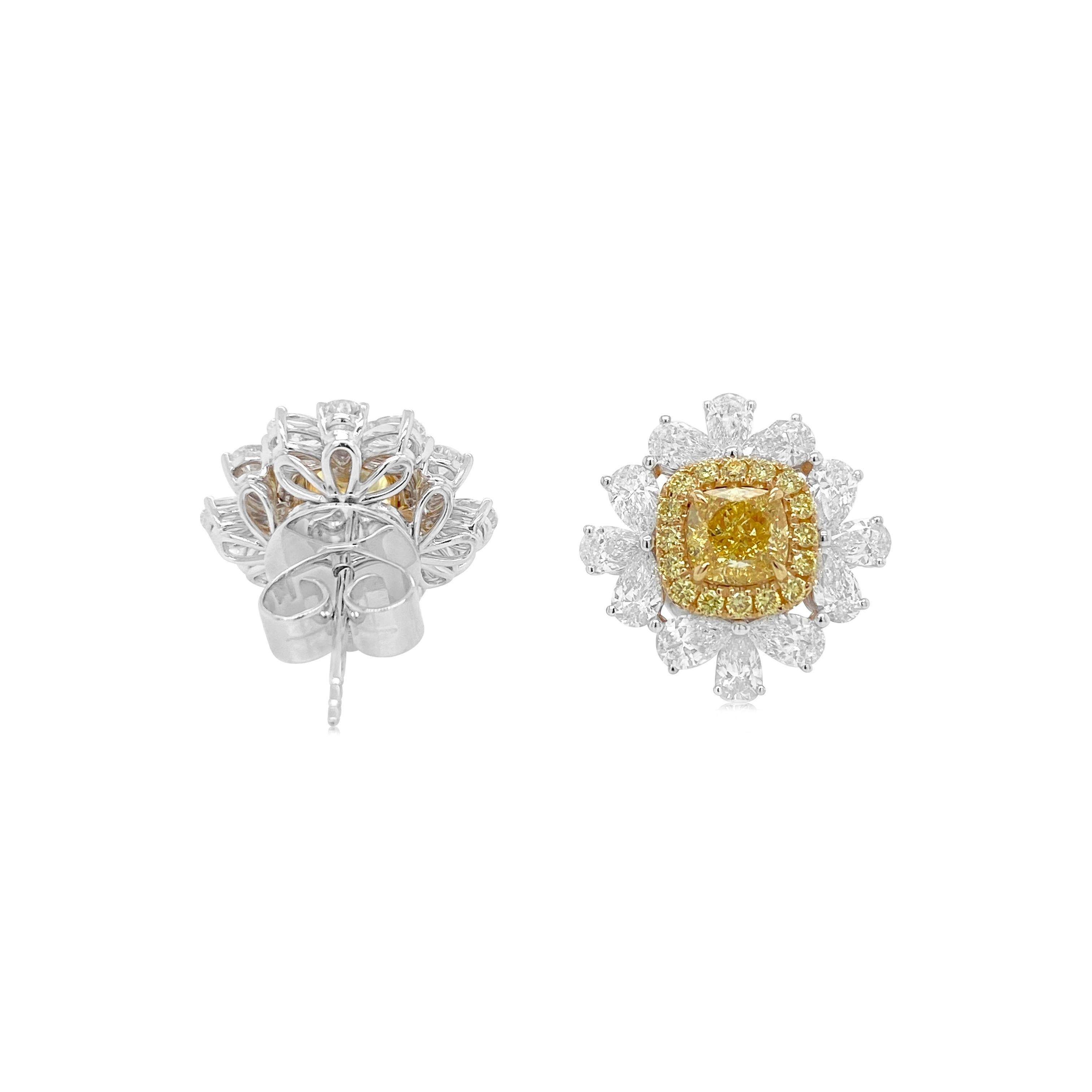 Boucles d'oreilles en or 18 carats composées d'un diamant jaune fantaisie certifié GIA à taille coussin, mis en valeur par un halo de diamants blancs éblouissants. Le contraste frappant entre les centres jaune vif et les diamants blancs brillants