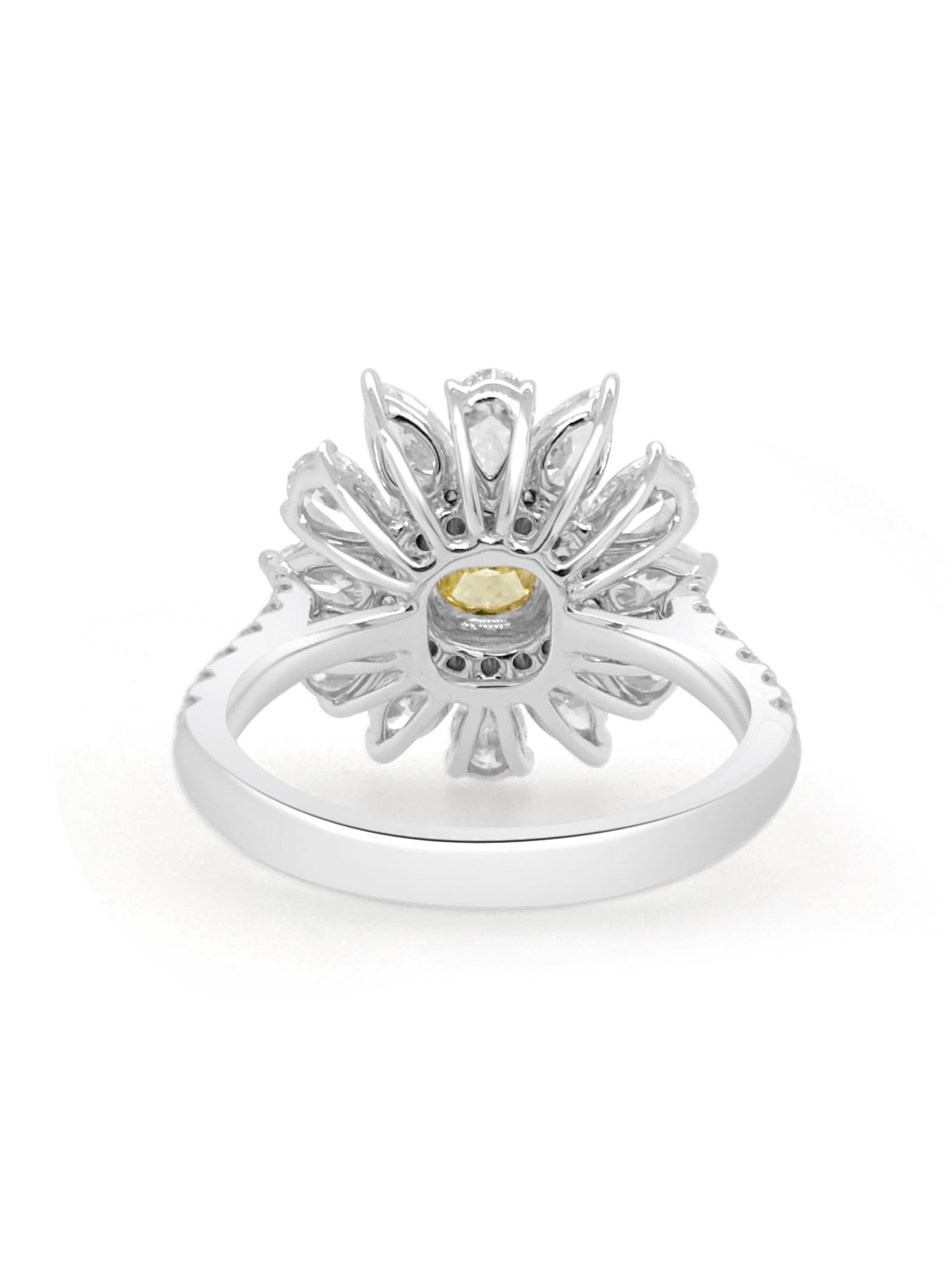 Dieser exquisite Ring zeigt einen GIA-zertifizierten gelben Fancy-Diamanten im Kissenschliff in der Mitte, umgeben von gelben Diamanten im Brillantschliff und weißen Diamanten im Birnenschliff, die in einem zarten Blumendesign angeordnet sind. Der