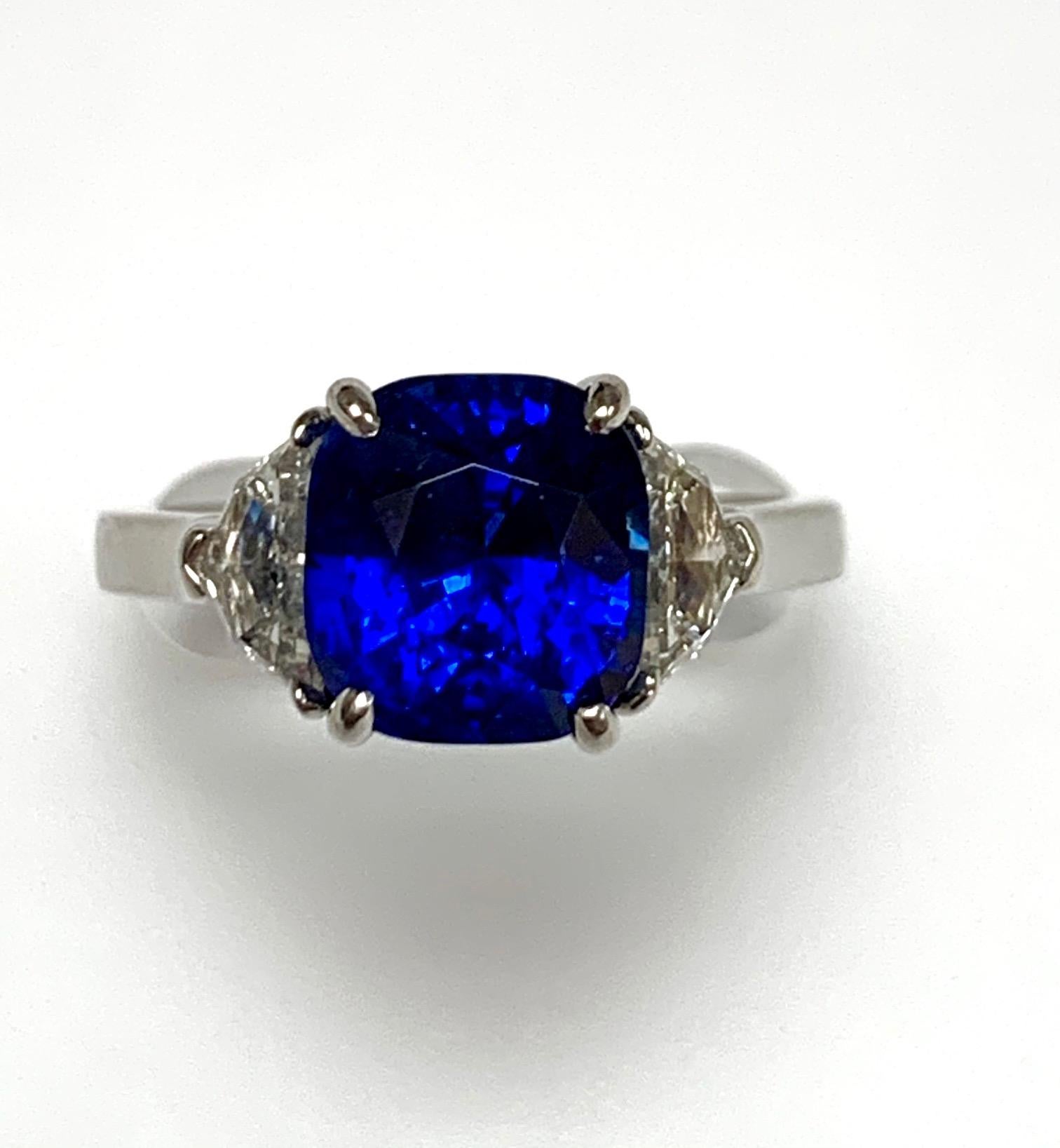 4.50 ct Cusion shape Royal  blue sapphire certified by GIA , heat , set in platinum hand made three stone ring along with 0.99 ct H vs2 eapulette diamonds , very clean , livley sapphire , modern classic ring .