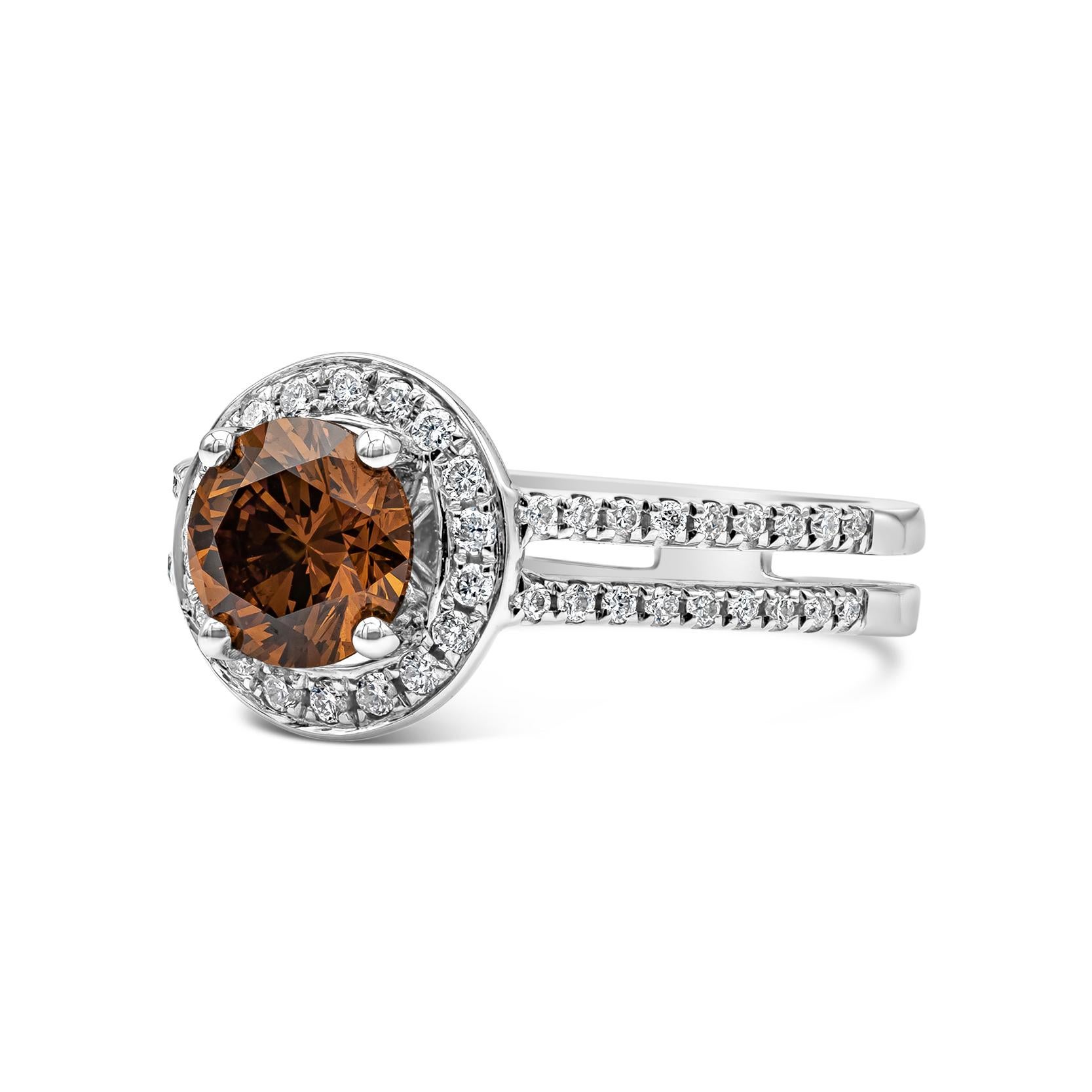 Showcasing a very vibrant 1.05 carat round diamond certified by GIA as Fancy Deep Brownish Yellow Orange Color, SI2 Clarity. Surrounding the center diamond are round brilliant white diamonds in a double shank mounting. Finely Made in 18K White