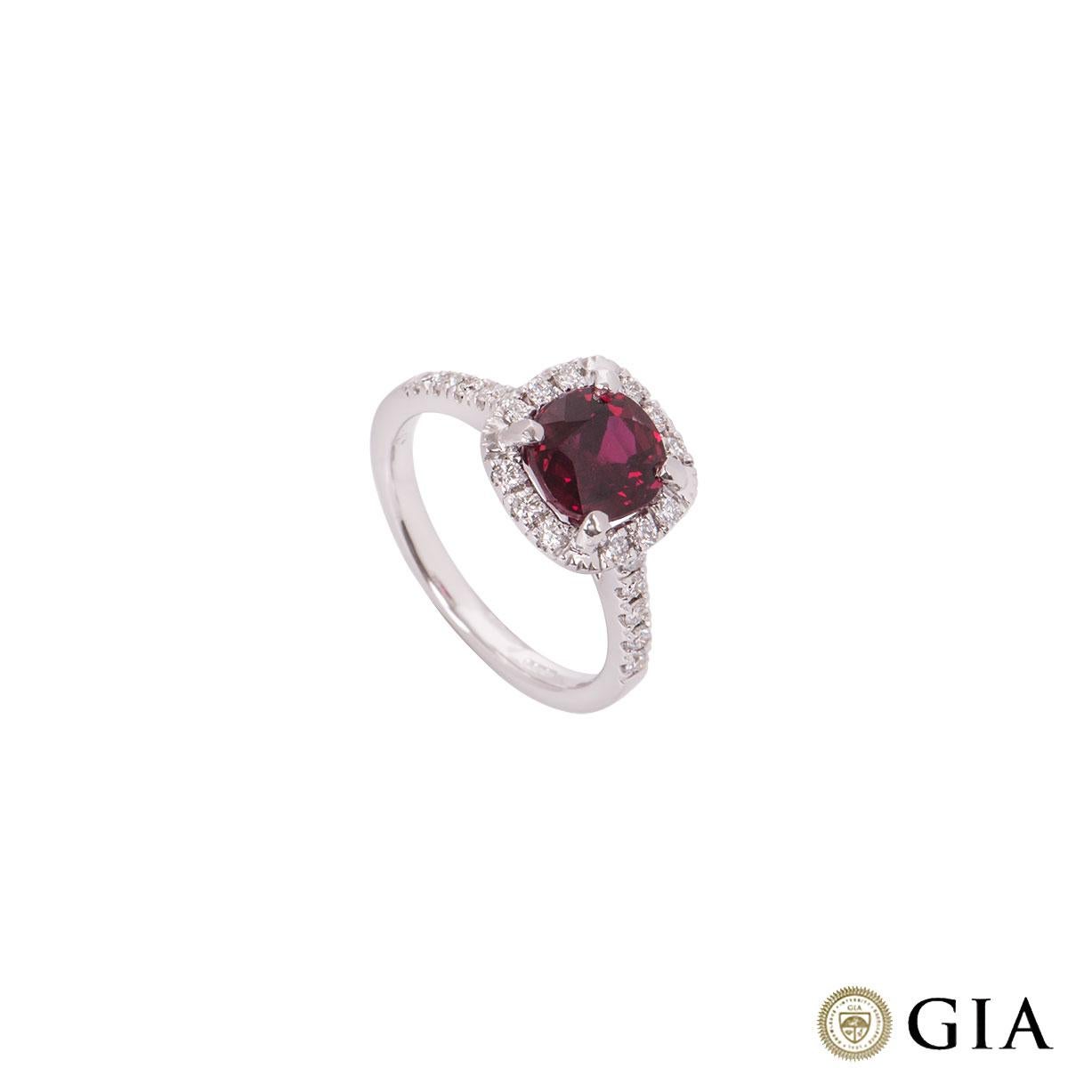 An 18k white gold diamond and ruby ring. The ring comprises of a cushion cut ruby in a four claw setting in the centre with round brilliant cut diamonds in a halo setting and on the shoulders. The ruby has a weight of 2.54ct and the diamonds have a
