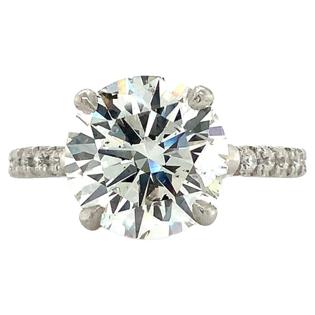 This exquisite engagement set features a GIA certified Round Brilliant Cut Diamond weighing 4.10 ct, accompanied by 14 Round Brilliant Cut Diamonds with a total weight of 0.47 ct. All diamonds in the set are G in color and have an SI2 clarity grade