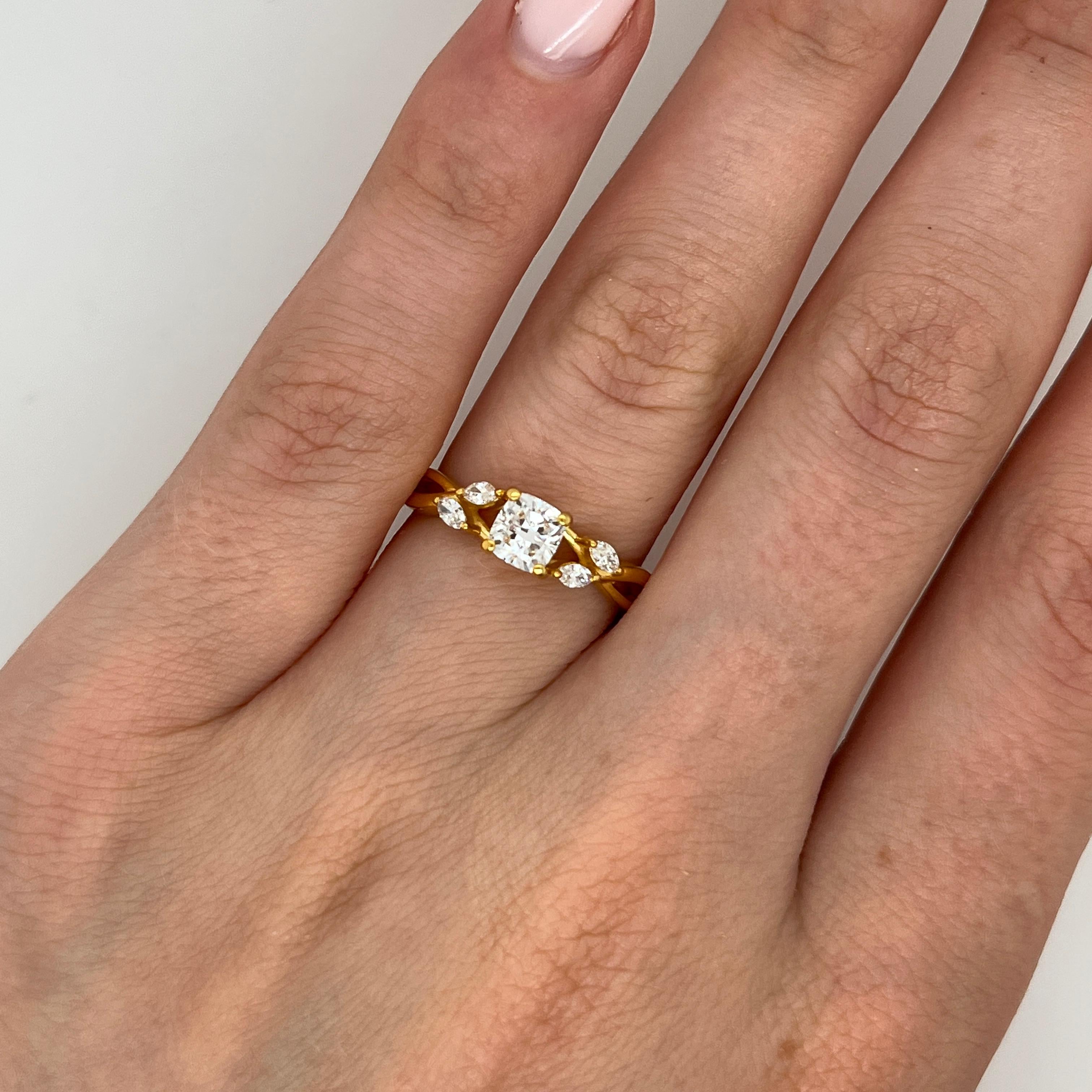 Un anillo atemporal de oro amarillo de 14k con un diamante redondo de talla brillante certificado por el GIA en el centro. Flanqueado por cuatro diamantes talla marquesa a cada lado, este diseño combina la elegancia clásica con un toque de encanto