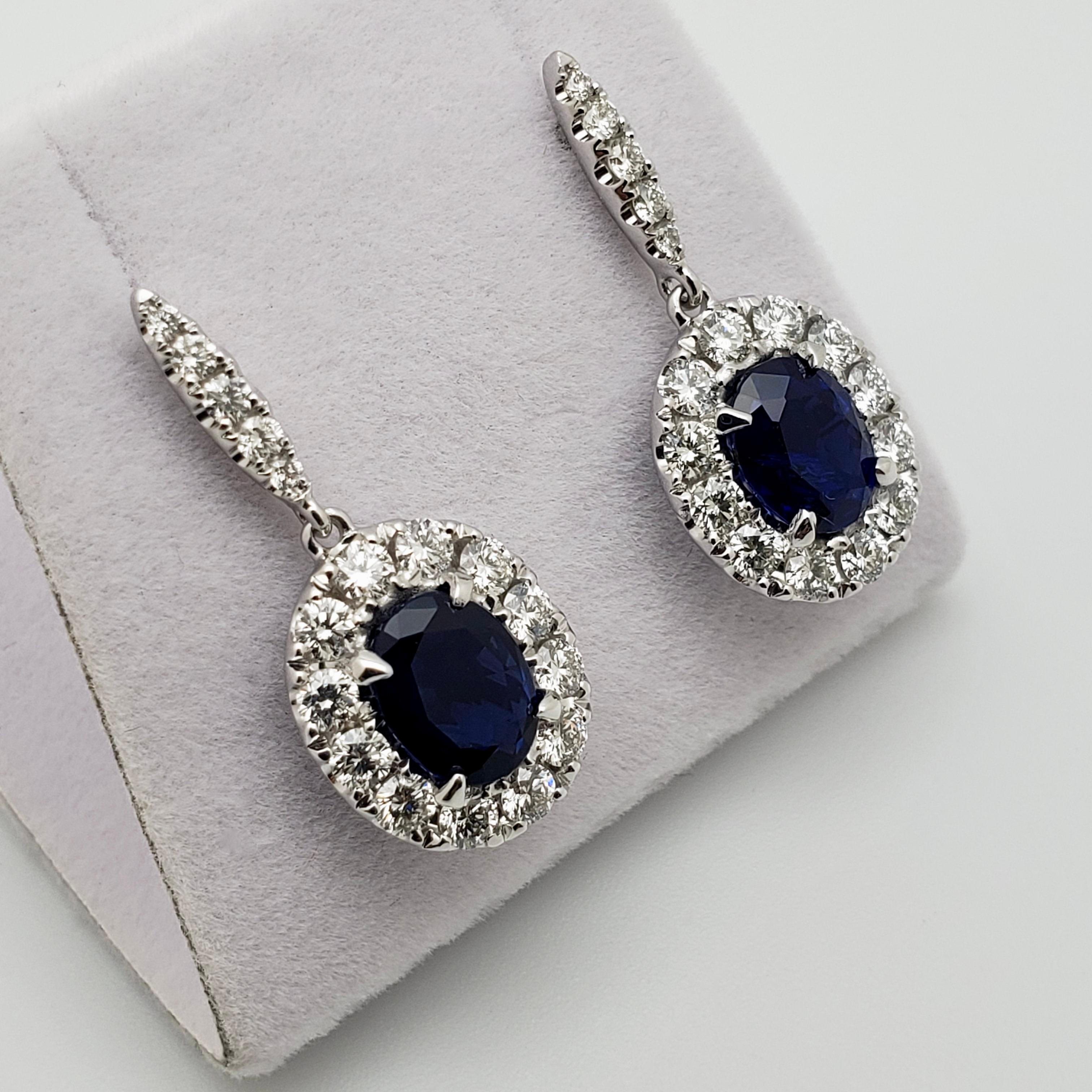 An extraordinary pair of 18K white gold diamond and sapphire earrings. Set with two natural unheated oval cut midnight-blue sapphires, accompanied by a GIA Certificate stating natural corundum and no treatment (no indications of heating) report